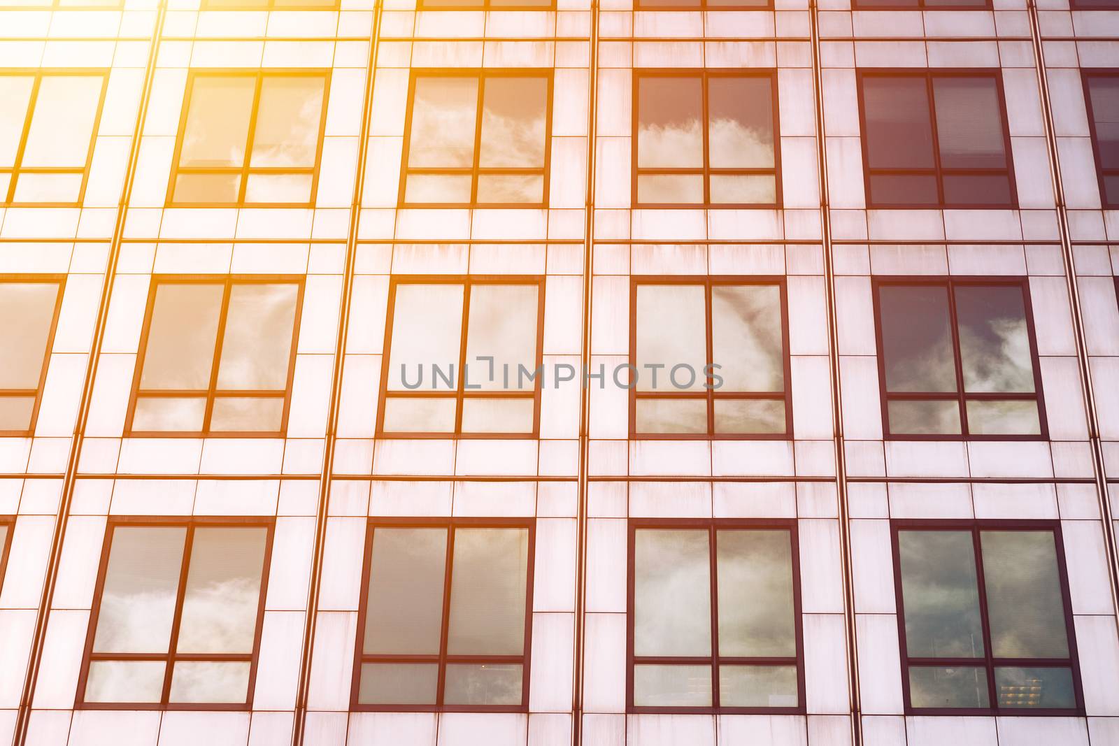 Sun ray and blue sky reflection on window office building, business concept