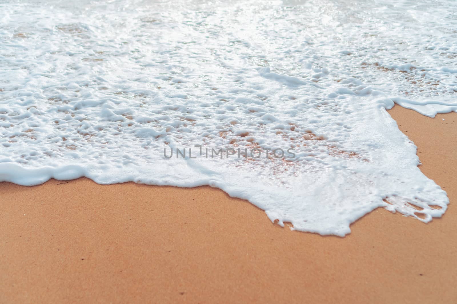 Top view of sand and water clean beach and white sand in summer with sun light blue sky and bokeh background. by Suwant