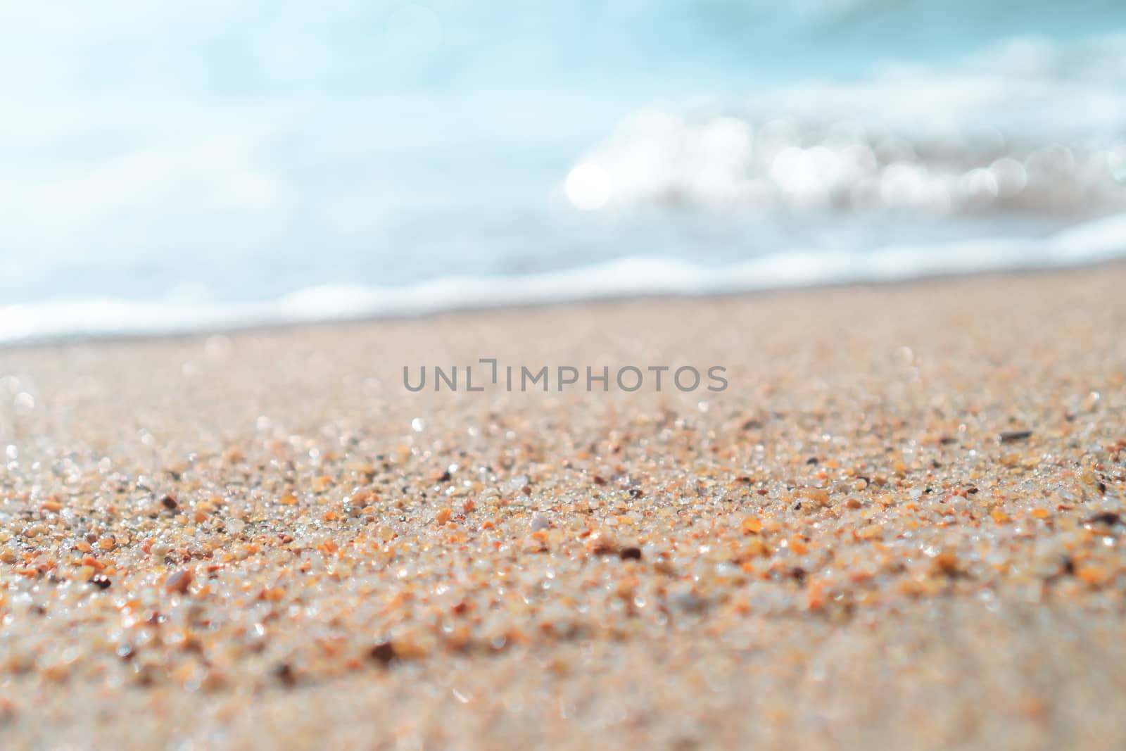 Top view of sand and water clean beach and white sand in summer with sun light blue sky and bokeh abstract  background.