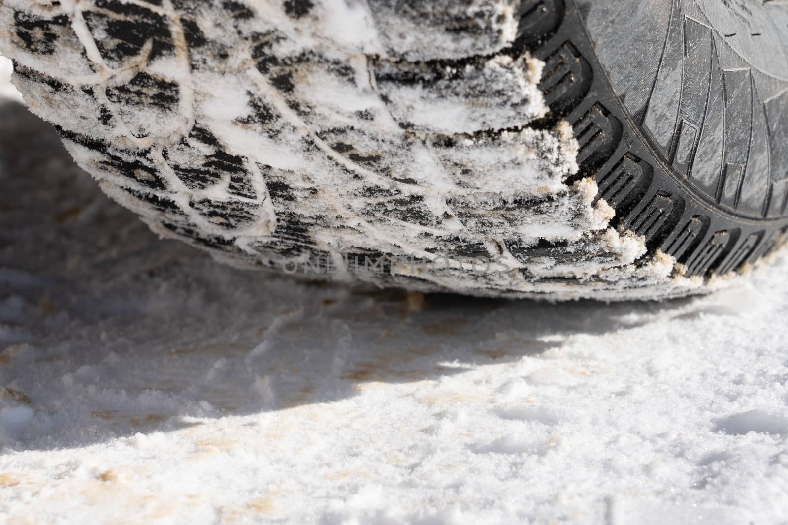 Tire for winter with spikes and its imprint on the road covered with snow