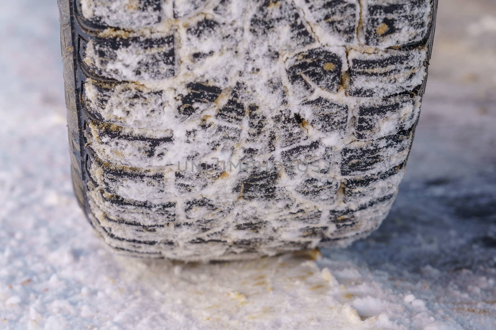 Tire for winter with spikes and its imprint on the road covered with snow