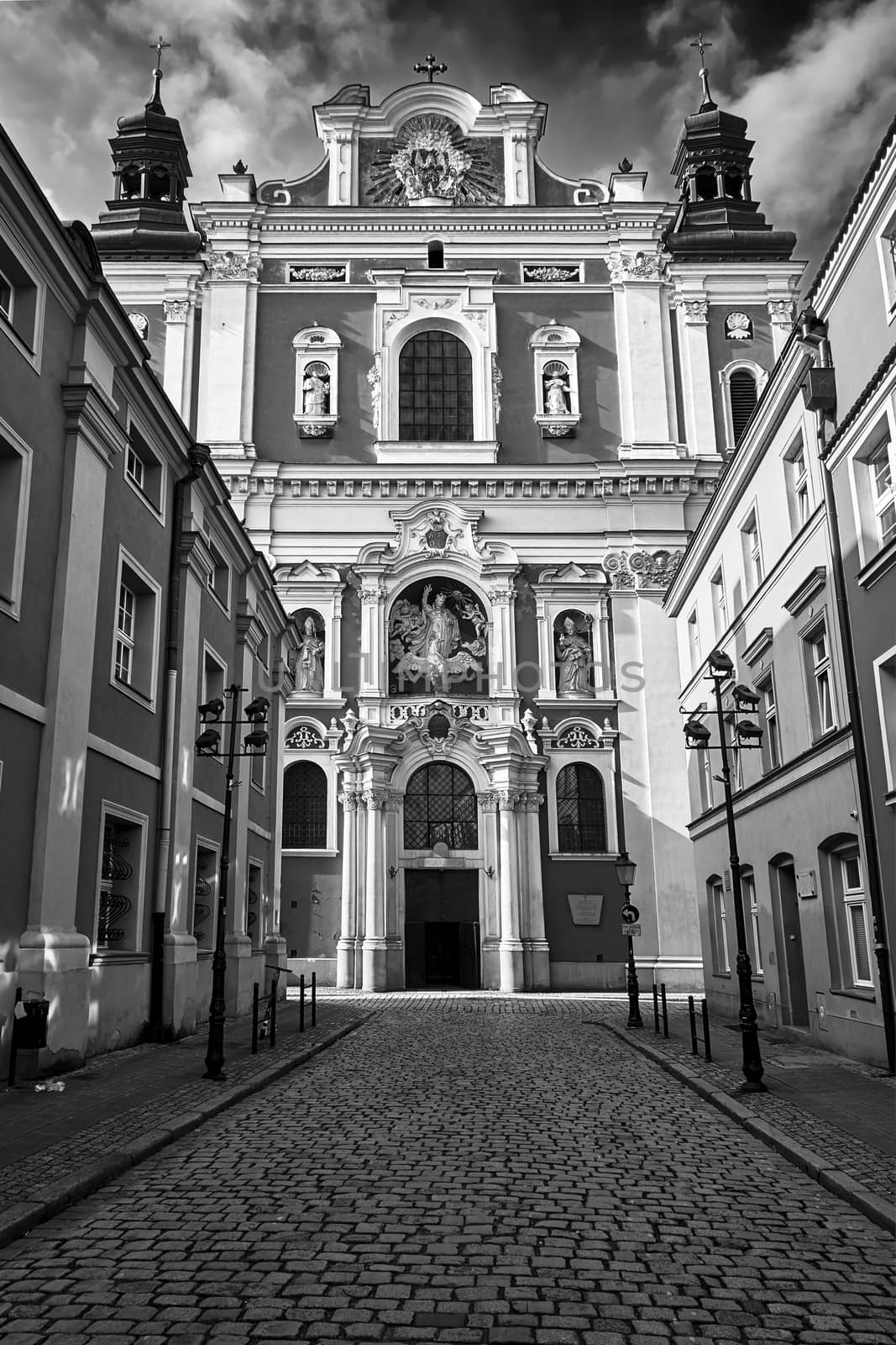 facade of the baroque church decorated with columns and statues in Poznan, black and white