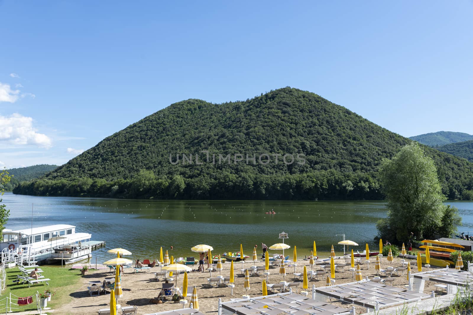 pidiluco,italy june 22 2020 :piediluco lake and its beach with ferry in the middle of the lake
