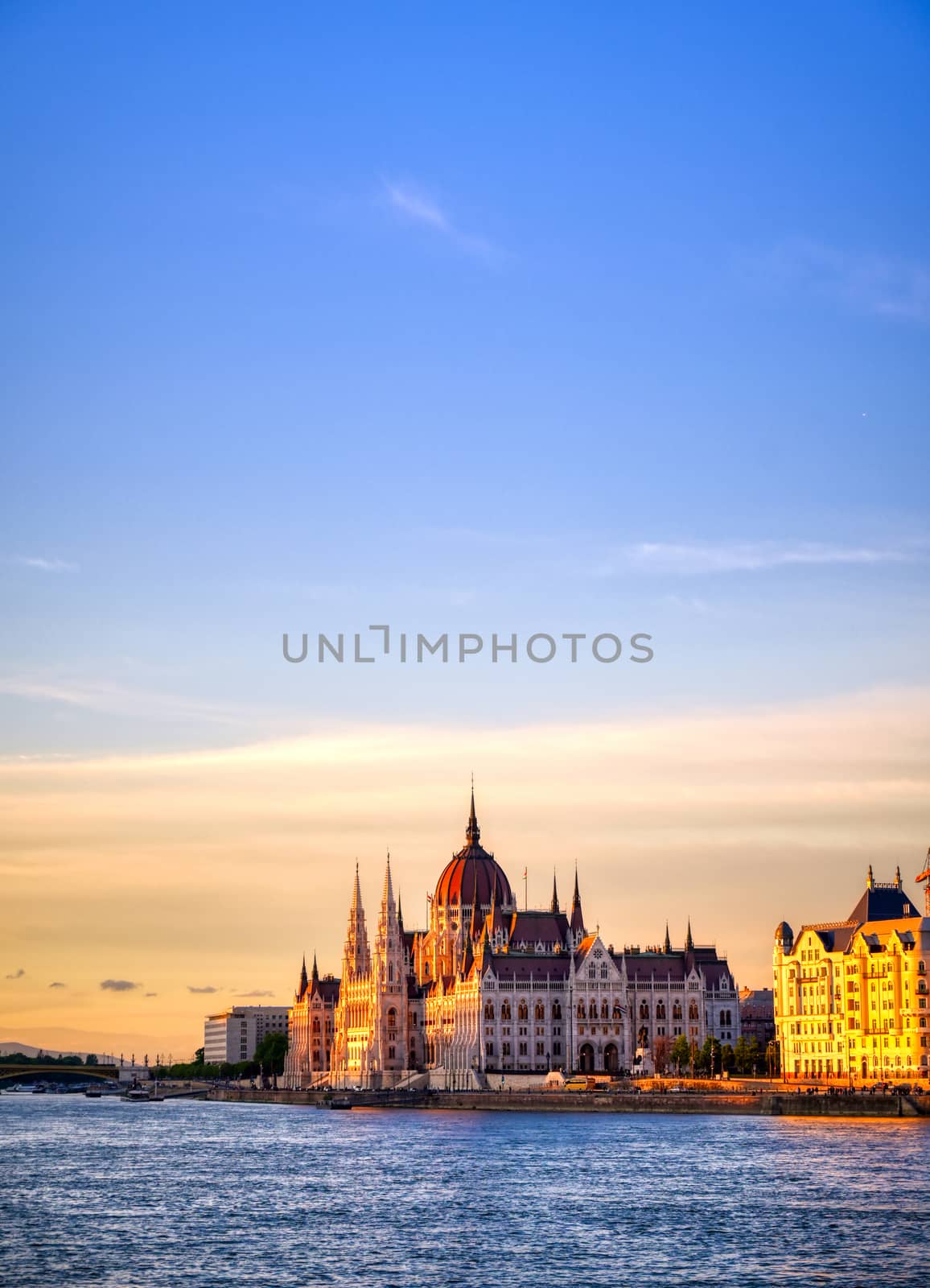 The Hungarian Parliament Building located on the Danube River in Budapest Hungary at sunset.