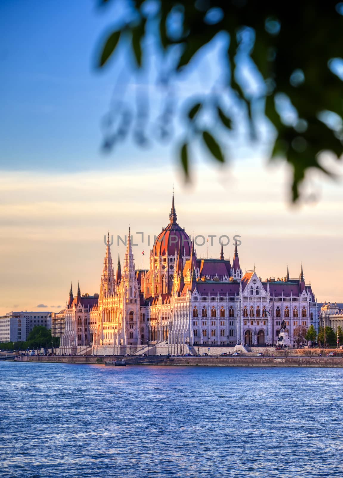 The Hungarian Parliament Building located on the Danube River in Budapest Hungary at sunset.