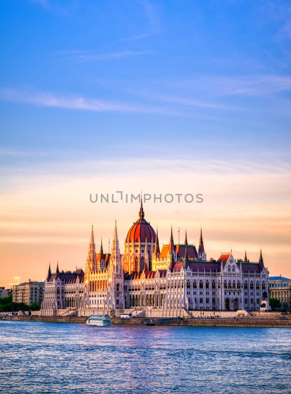 The Hungarian Parliament Building located on the Danube River in Budapest Hungary at sunset.