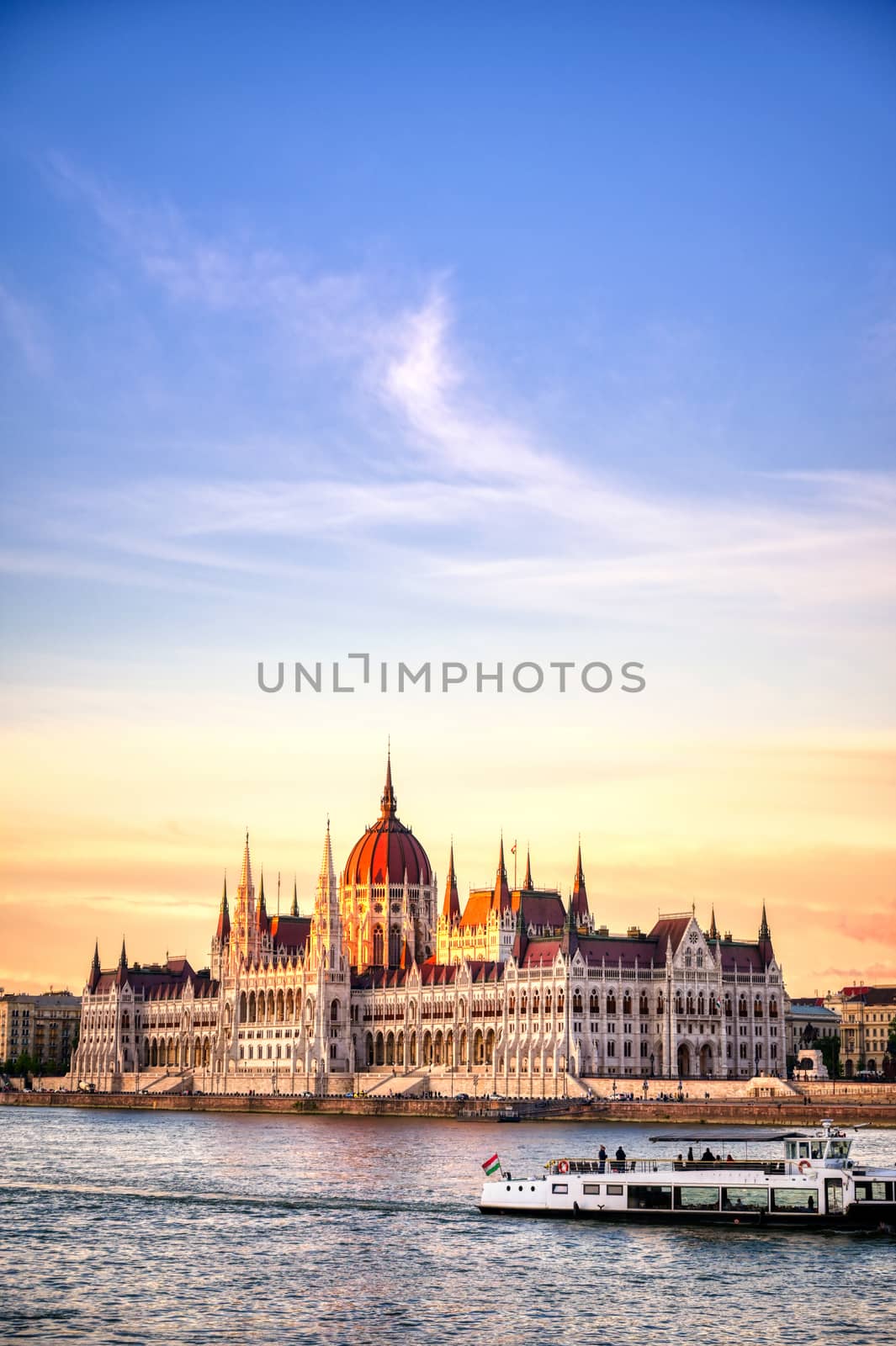 The Hungarian Parliament Building located on the Danube River in Budapest Hungary at sunset.