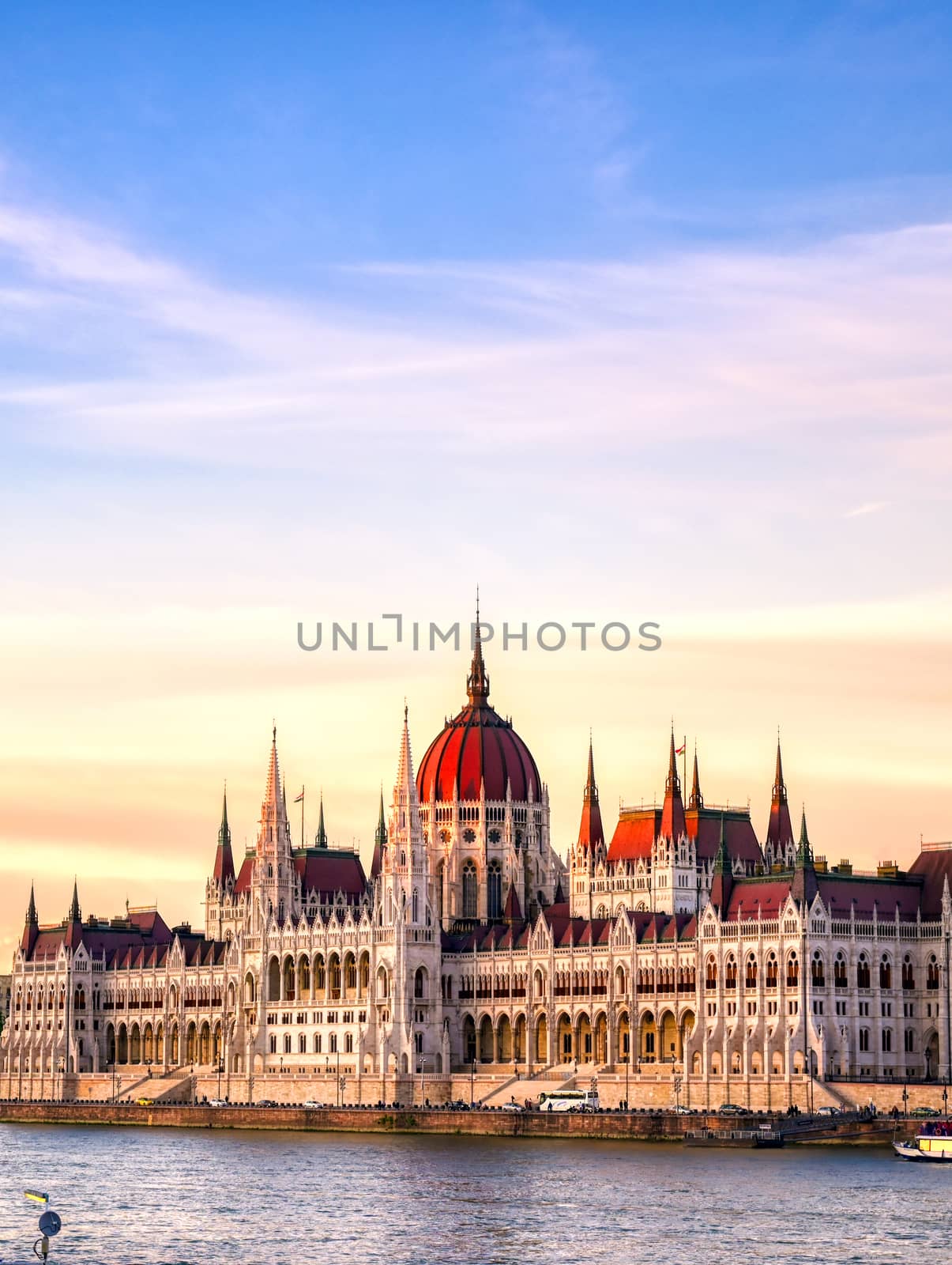 The Hungarian Parliament Building located on the Danube River in Budapest Hungary at sunset.