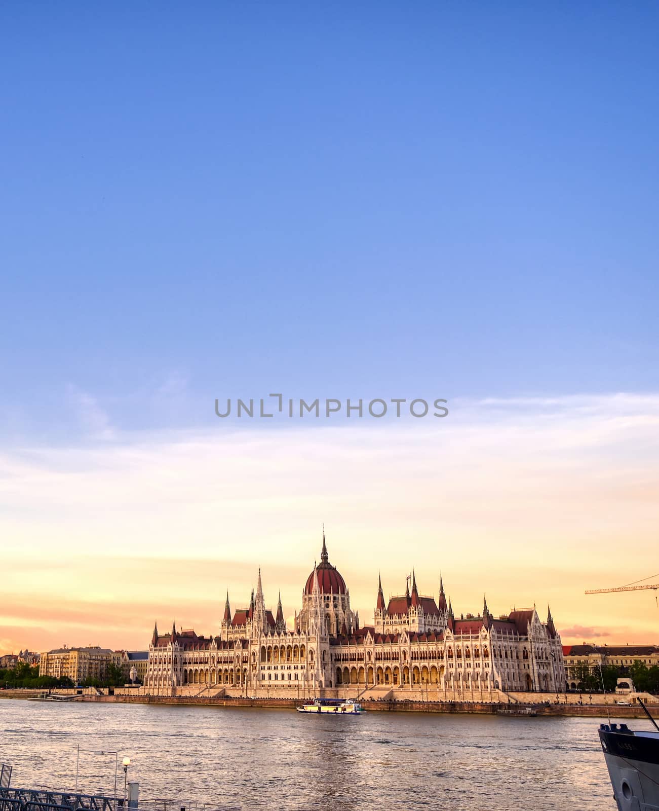 The Hungarian Parliament Building located on the Danube River in Budapest Hungary at sunset.