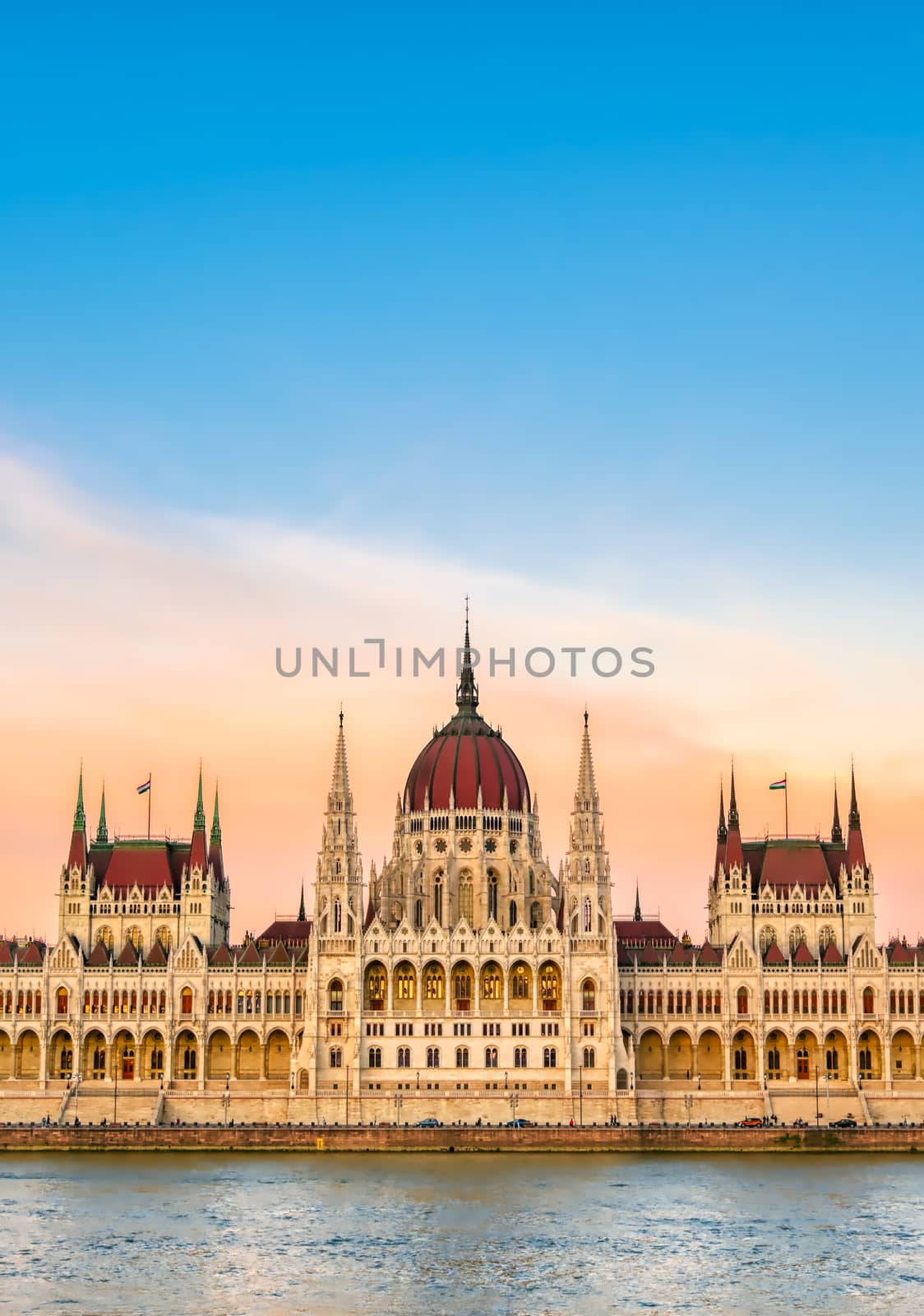 The Hungarian Parliament Building located on the Danube River in Budapest Hungary at sunset.