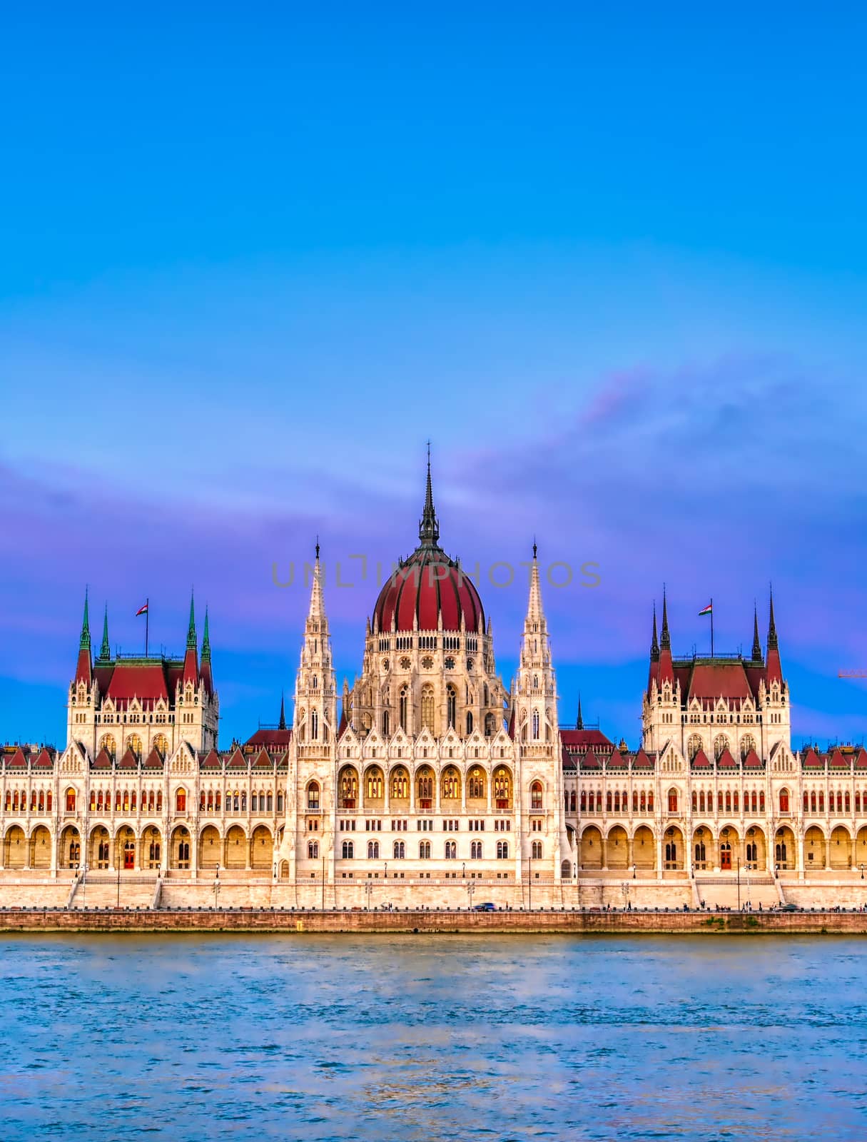 The Hungarian Parliament Building located on the Danube River in Budapest Hungary at sunset.