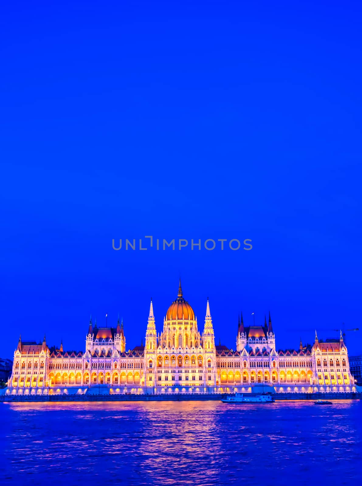 The Hungarian Parliament Building located on the Danube River in Budapest Hungary at sunset.