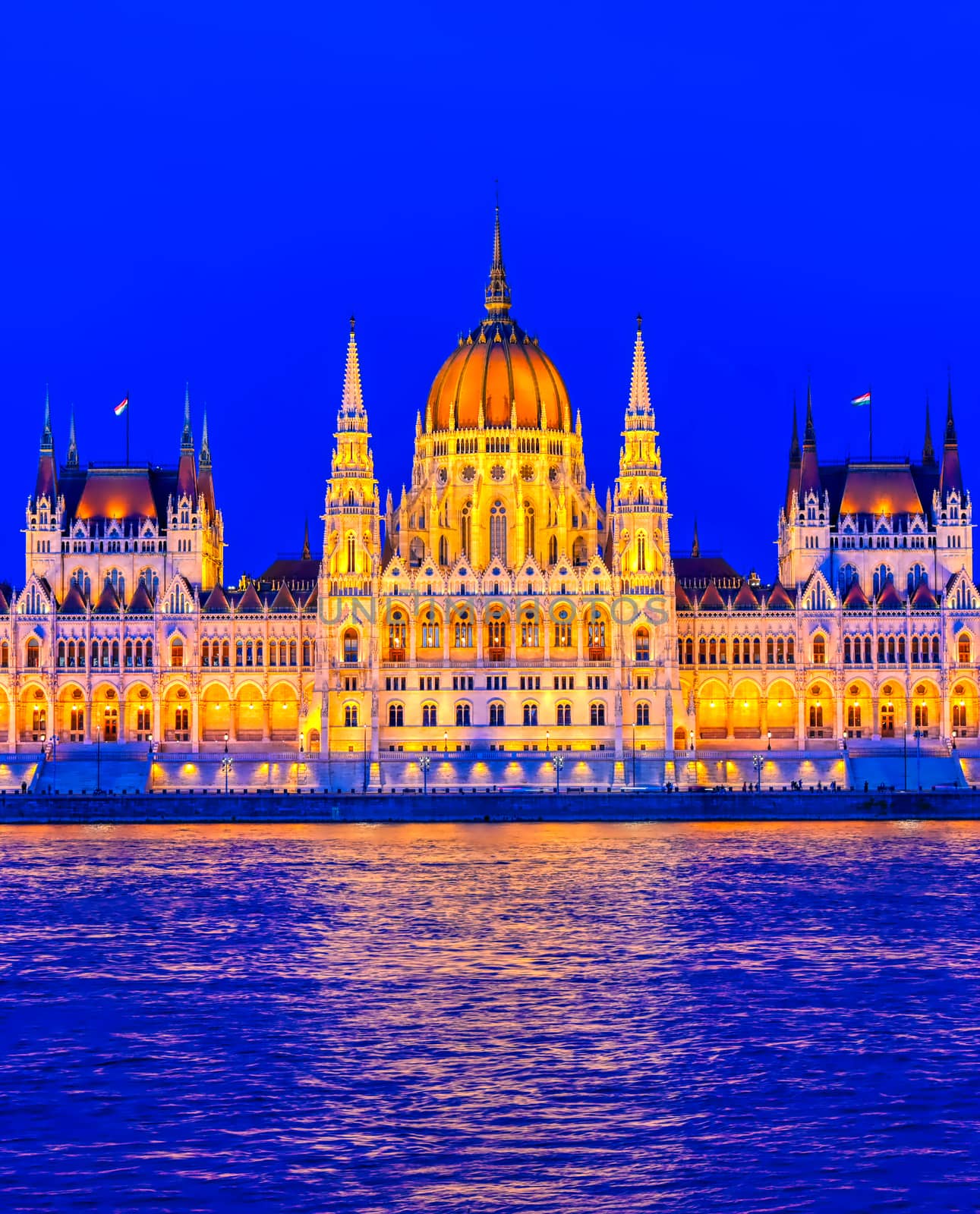 The Hungarian Parliament Building located on the Danube River in Budapest Hungary at sunset.