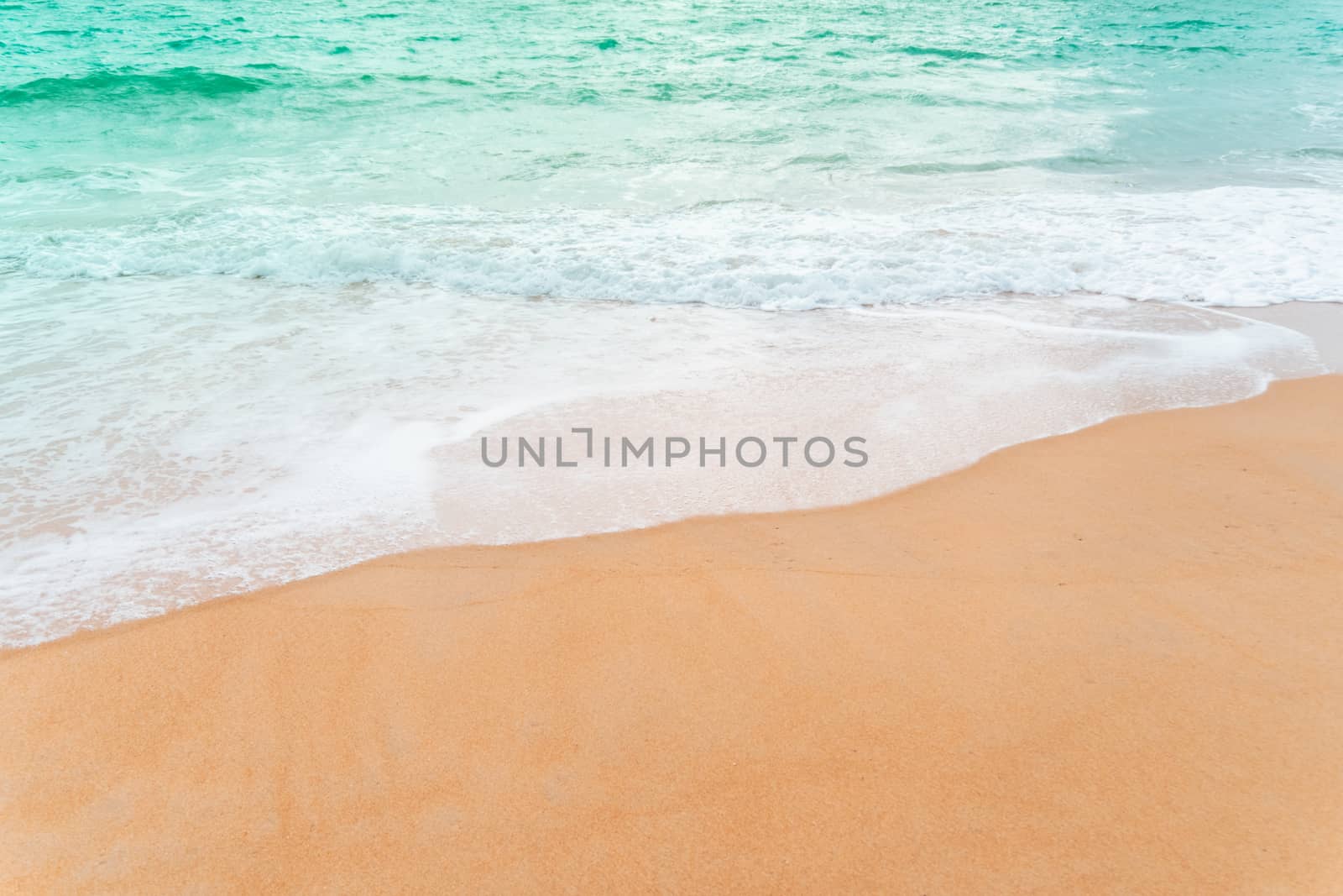 Top view of sand and water clean beach and white sand in summer with sun light blue sky and bokeh abstract  background.