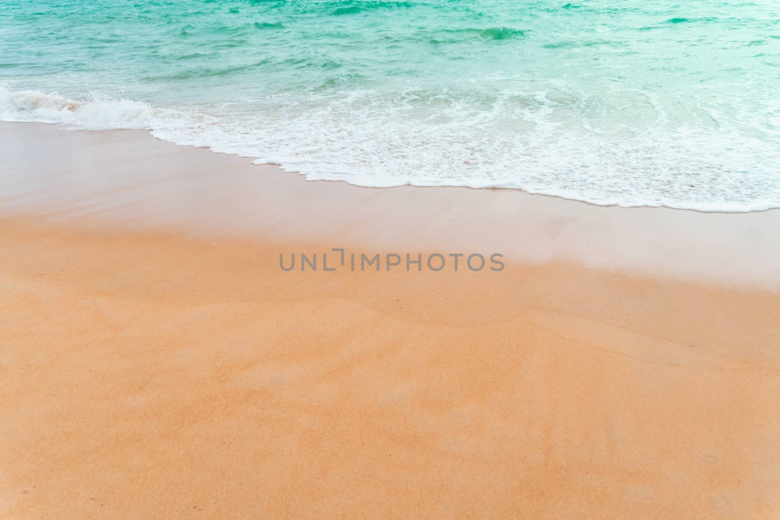 Top view of sand and water clean beach and white sand in summer with sun light blue sky and bokeh abstract  background.