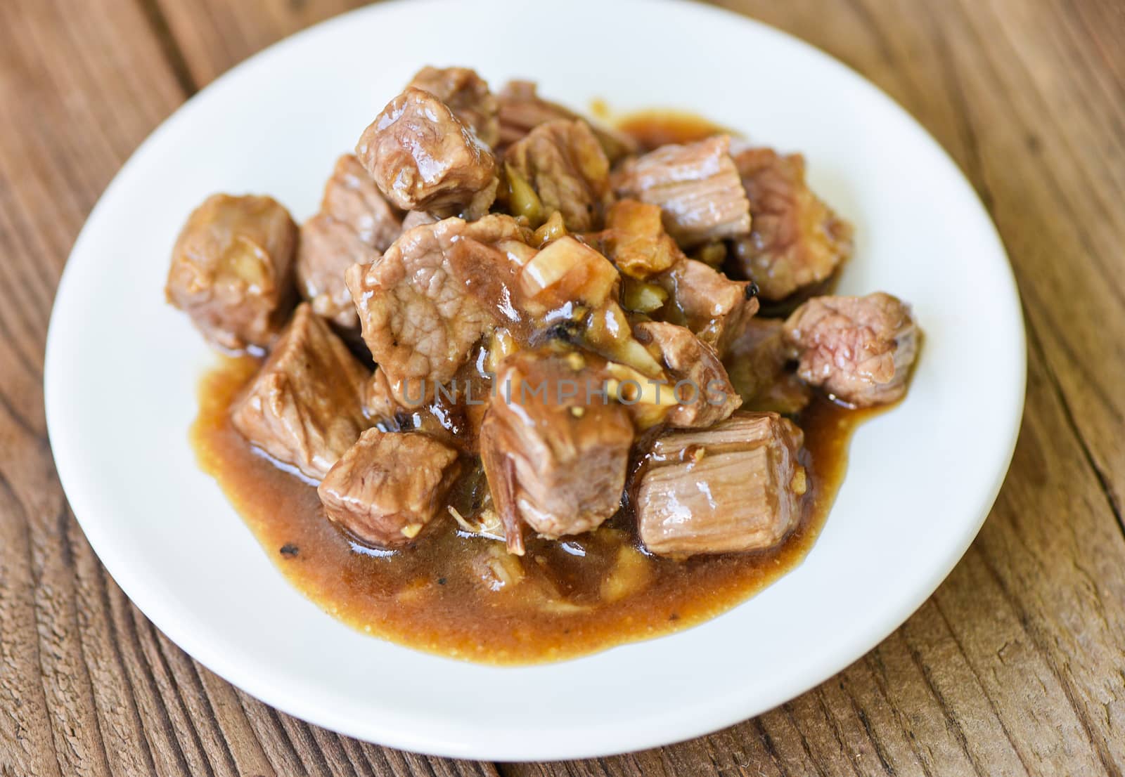 beef cuts and cooked food on white plate / meat beef cube roast bbq with sauce and spices garlic 