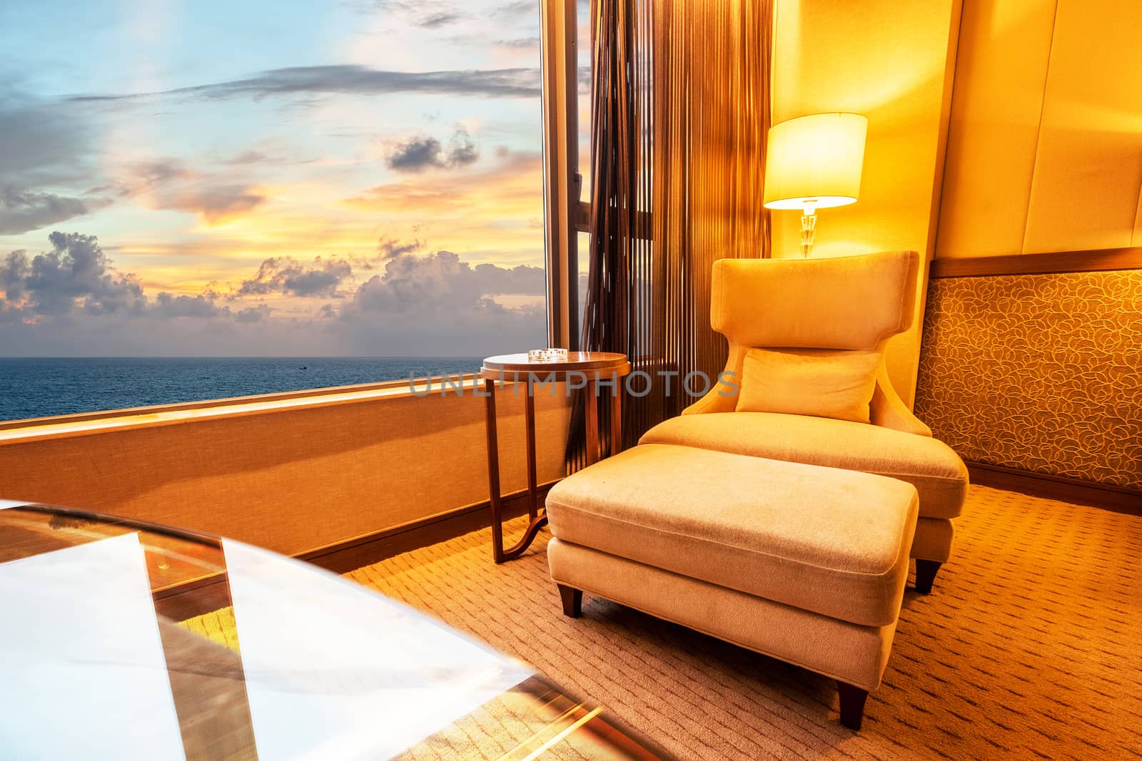 Sofa in living room in sunset at sea background 