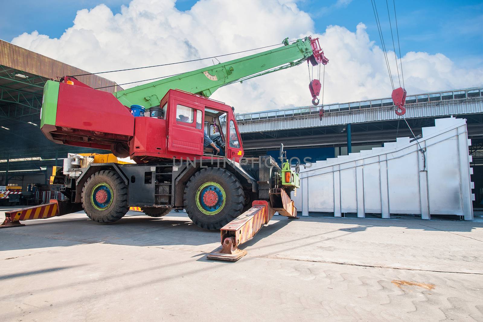 Mobile crane operating by lifting and moving an heavy electric g by Surasak