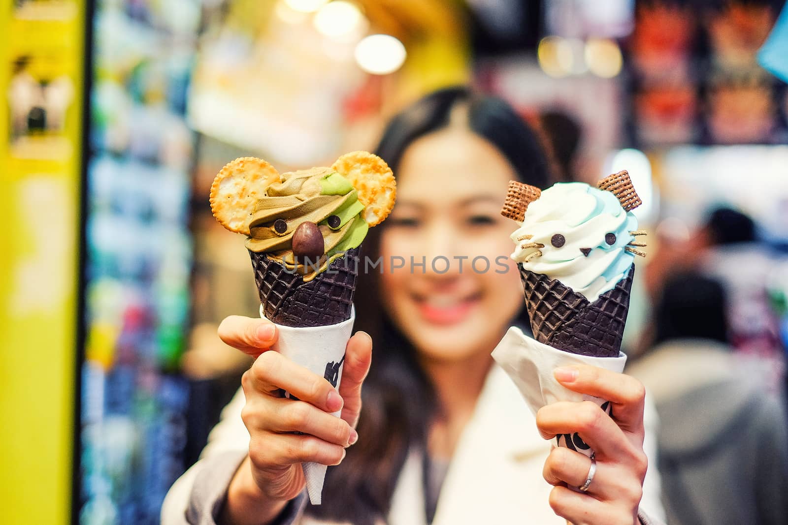 Asian young female model eating ice cream cone on Hong Kong Stre by Surasak