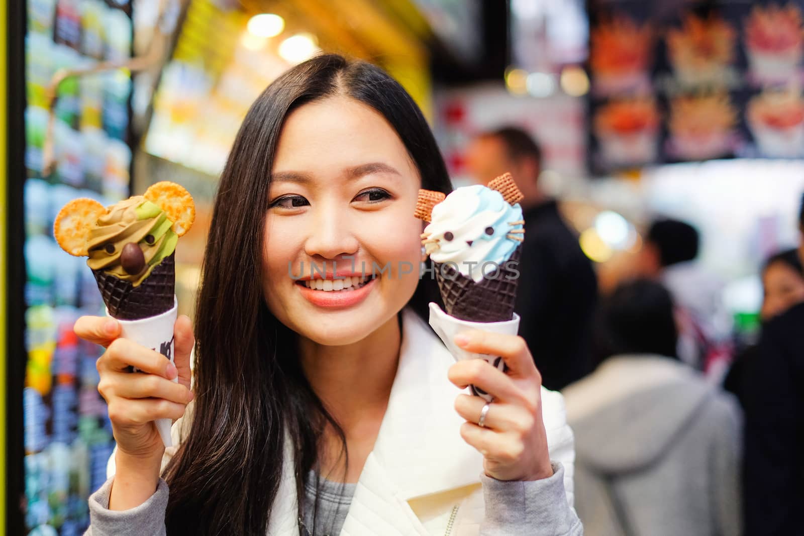 Asian young female model eating ice cream cone on Hong Kong Stre by Surasak