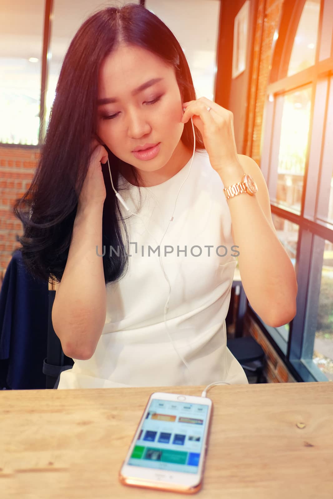 Young woman listening to music in coffee shop