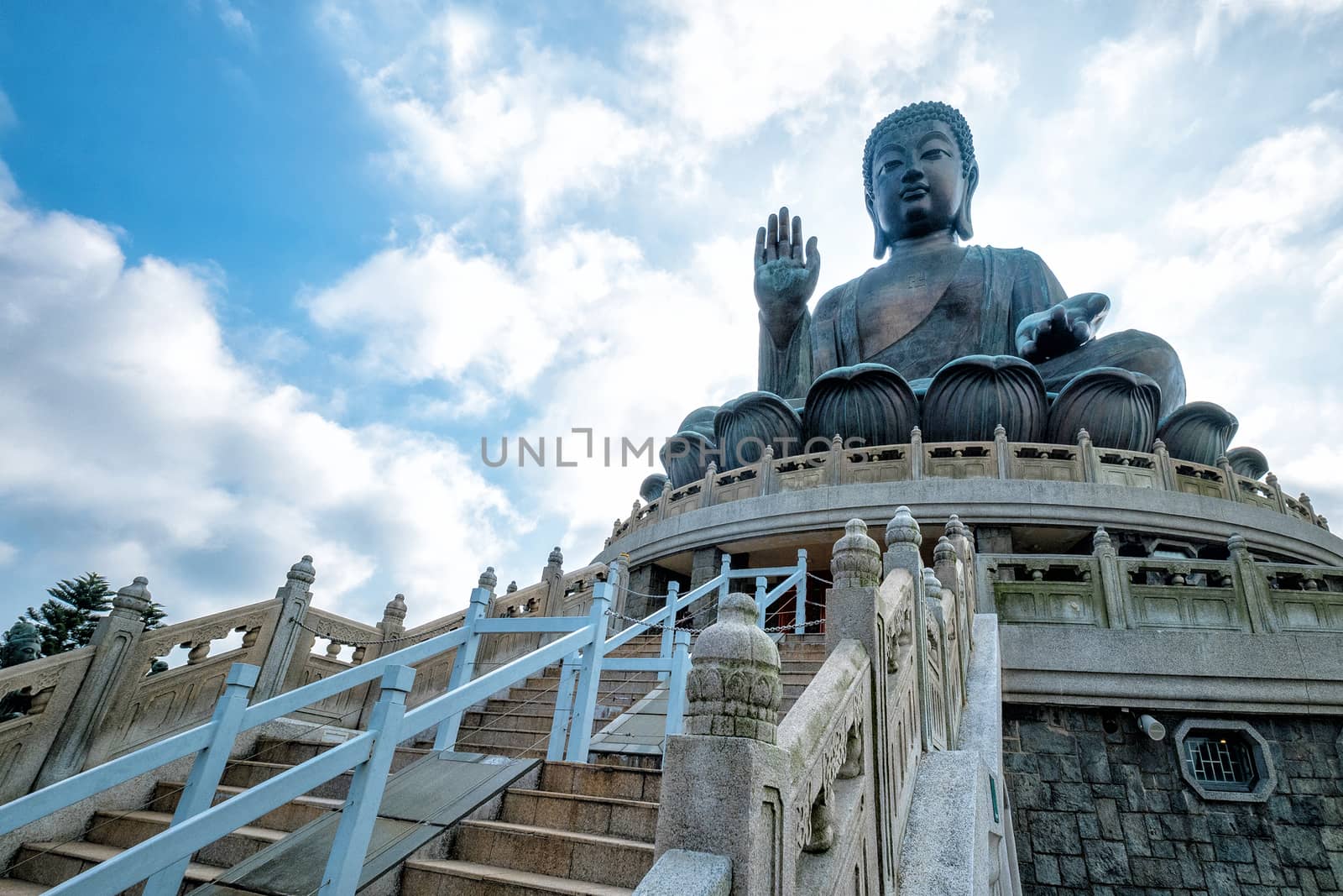 Front View of Tian Tan Giant Buddha in blue sky by Surasak