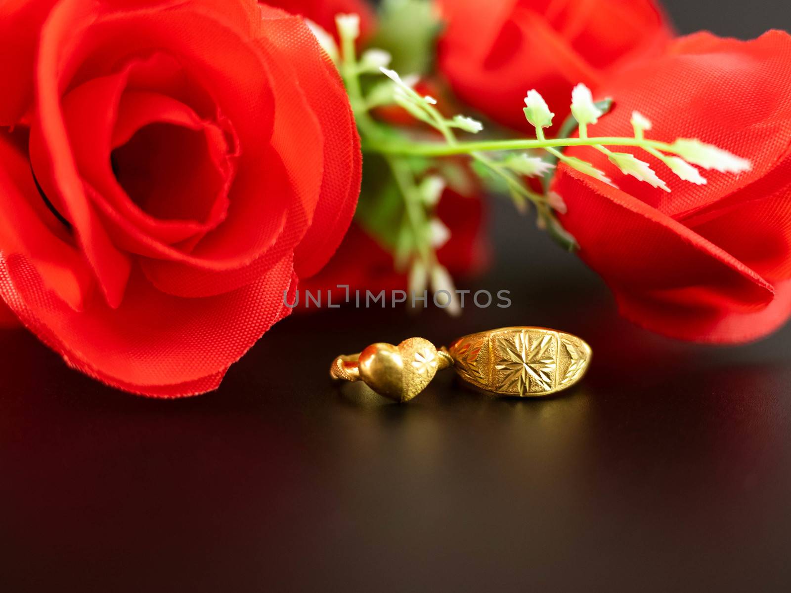 Wedding celebration on valentines day with red rose bouquet, wedding rings, isolated on dark background. Concept of love and romance. by TEERASAK