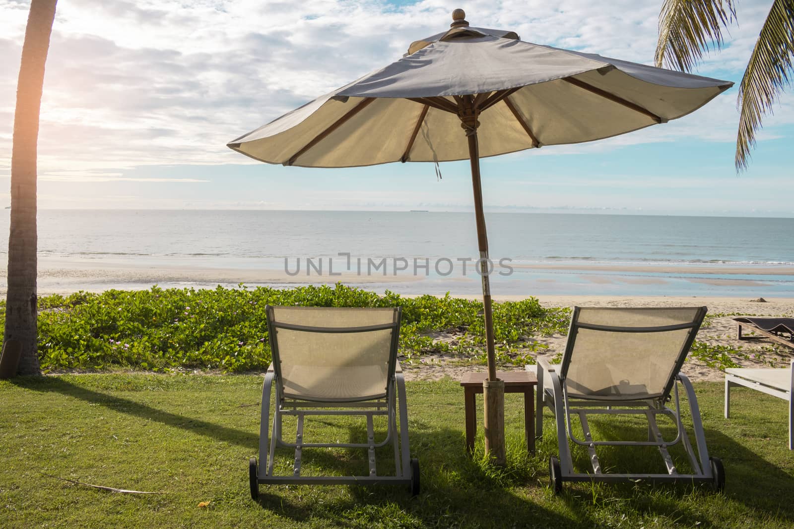 Beach chair and umbrella on sand beach by Gobba17