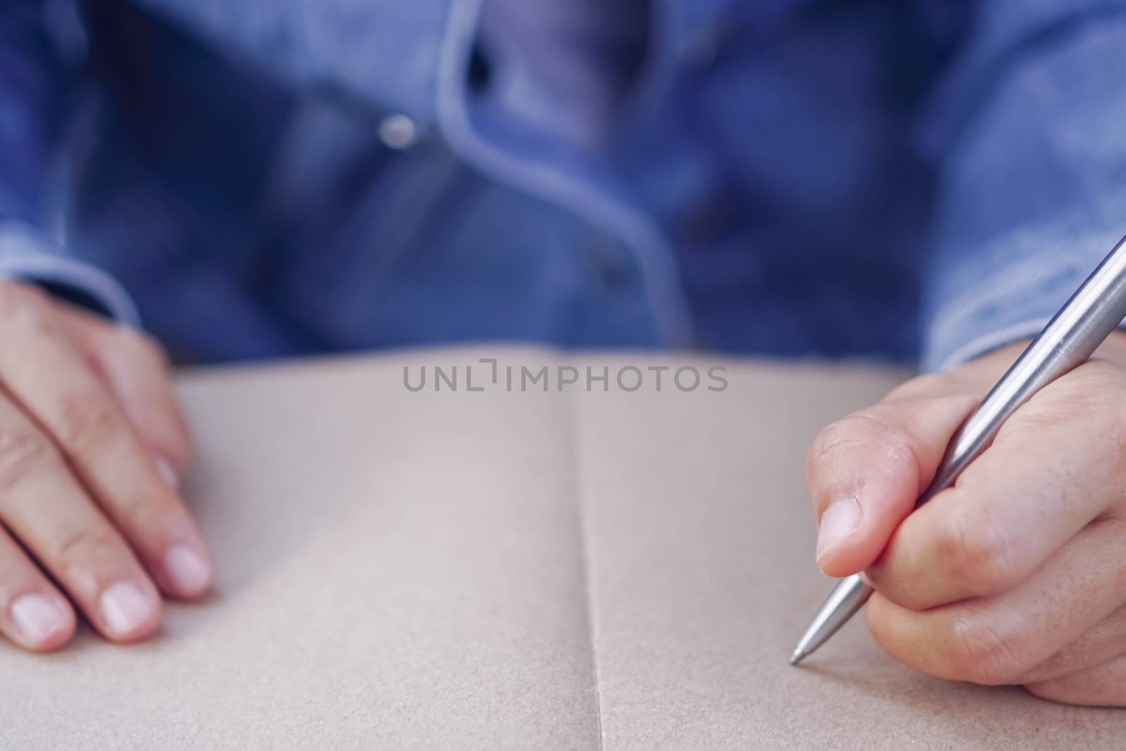 Copy space of woman hand writing down in white notebook with colorful bokeh background.