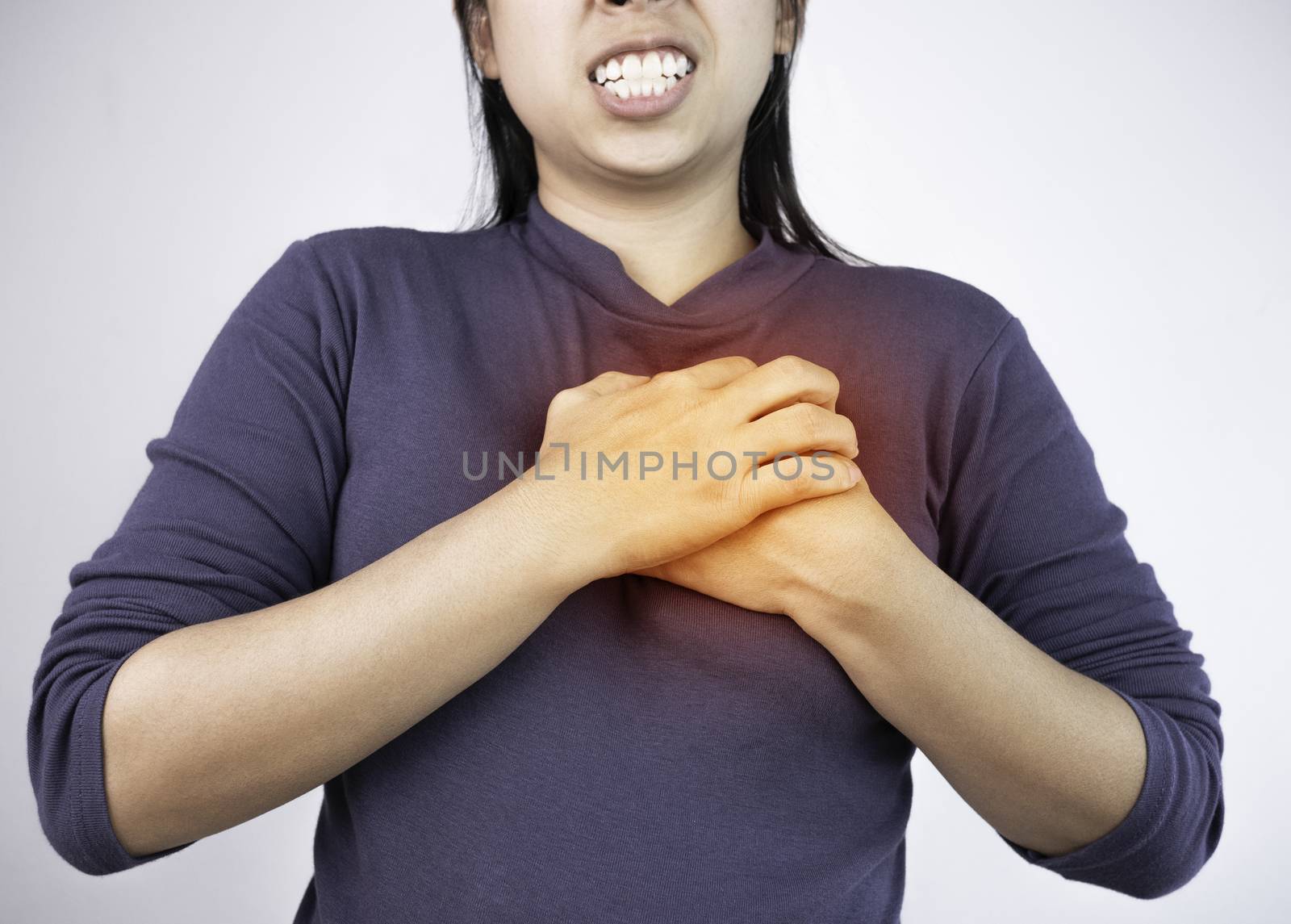 Woman catching on chest because she have pain from heart disease by TEERASAK