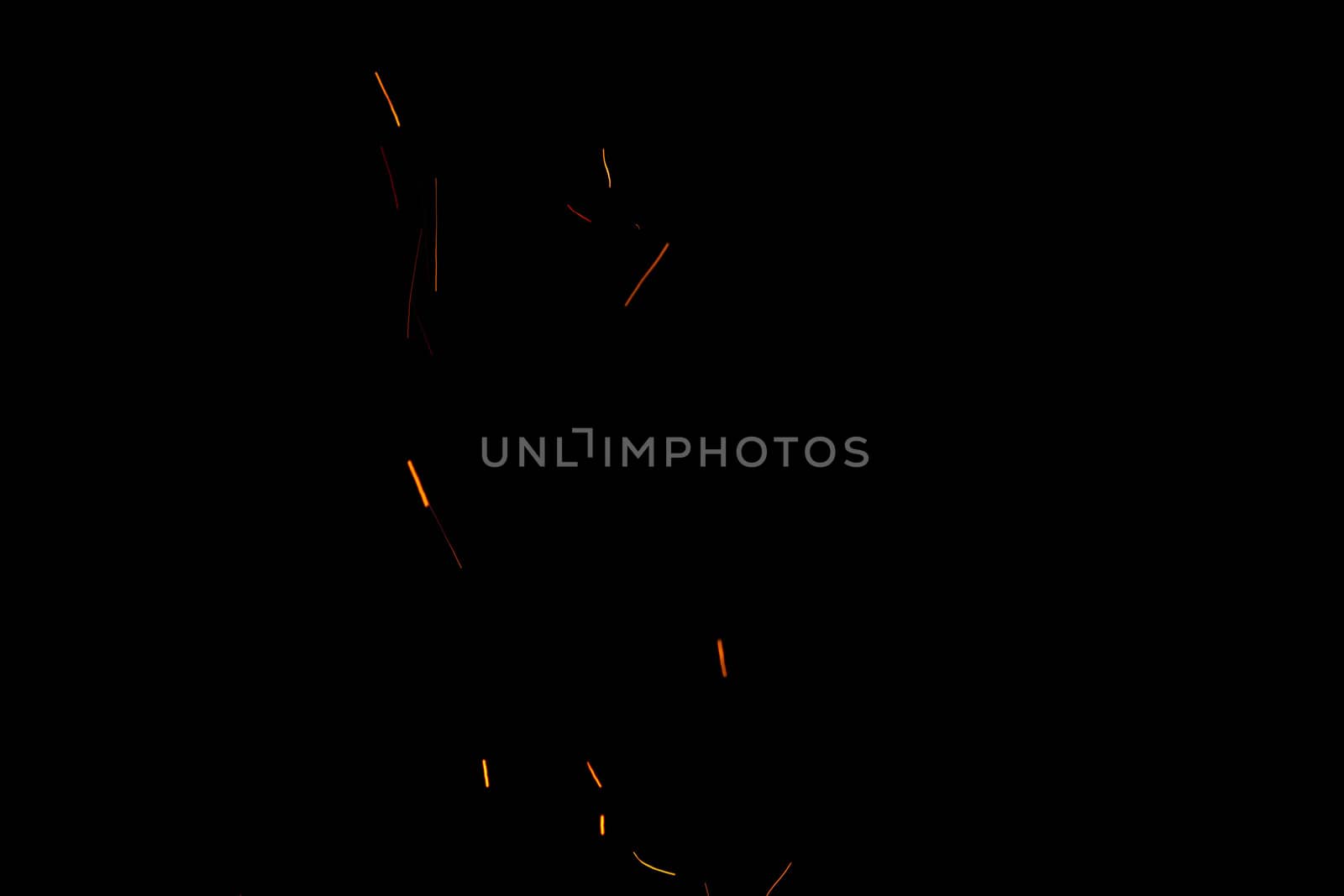 Burning red hot flying with sparks in the night sky. Beautiful abstract background of fire sparks particles on black background.