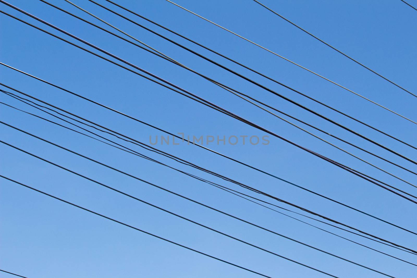 Electrical wires on blue sky background. by TEERASAK