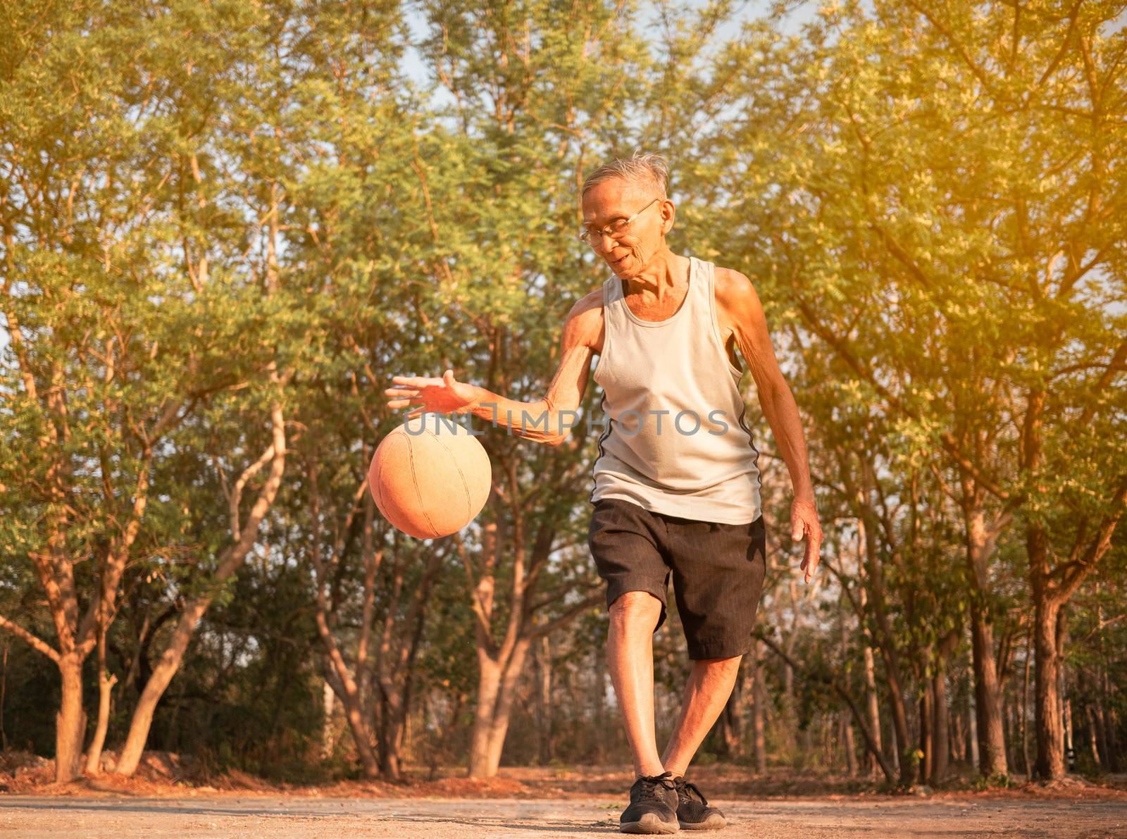Asian elderly men playing basketball on playground on summer day. Healthy lifestyle and Healthcare concept. by TEERASAK
