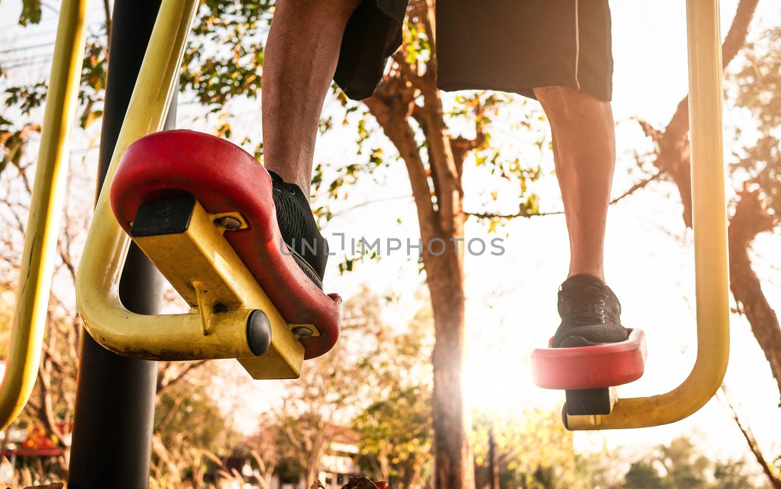 Close up Legs of Asian senior man in sporty clothes exercising for good health on outdoor fitness equipment in a public park on sunshine day. healthy lifestyles concept.