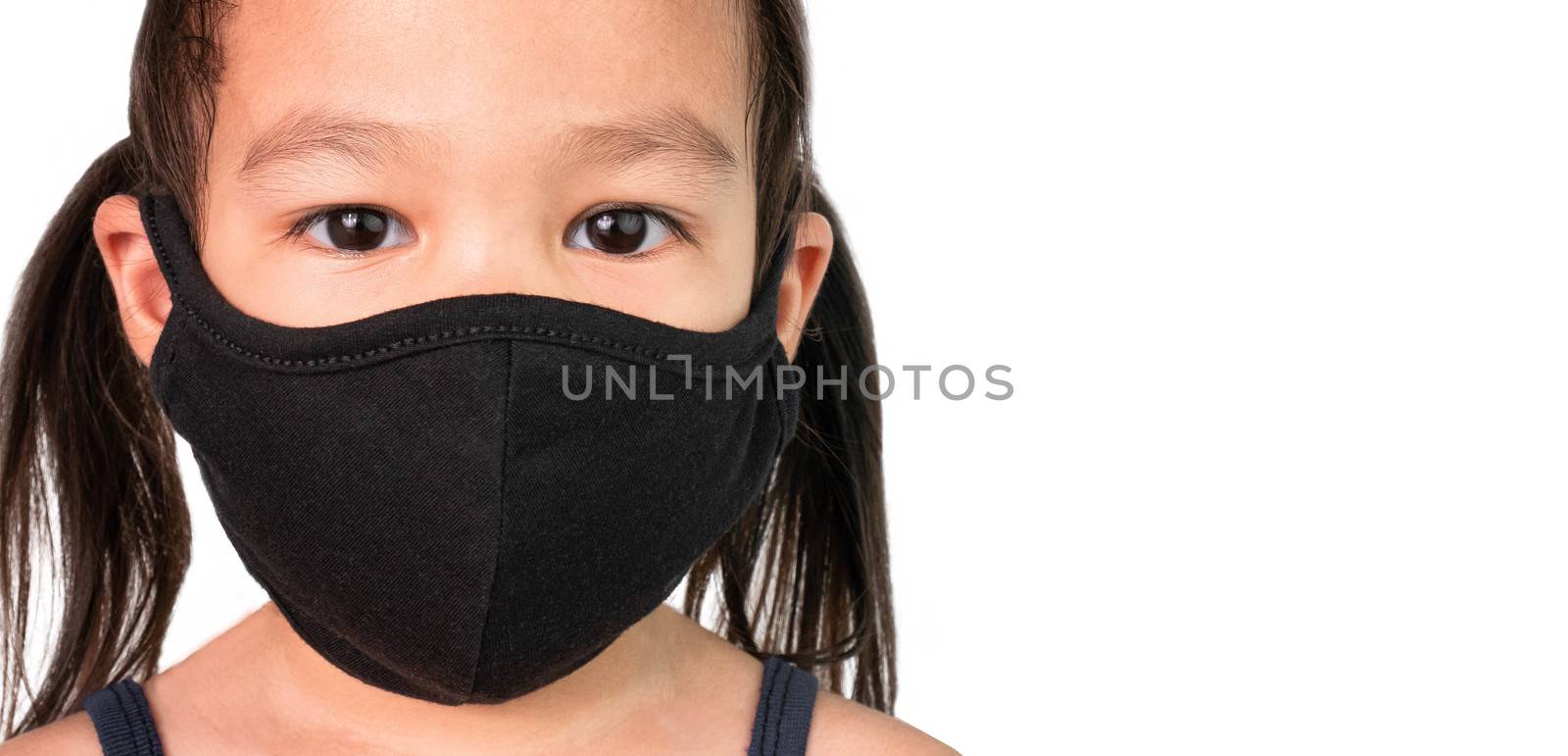 Portrait of Asian child girl wearing facial mask for protection from air pollution or virus epidemic on white background. Health care concept. by TEERASAK