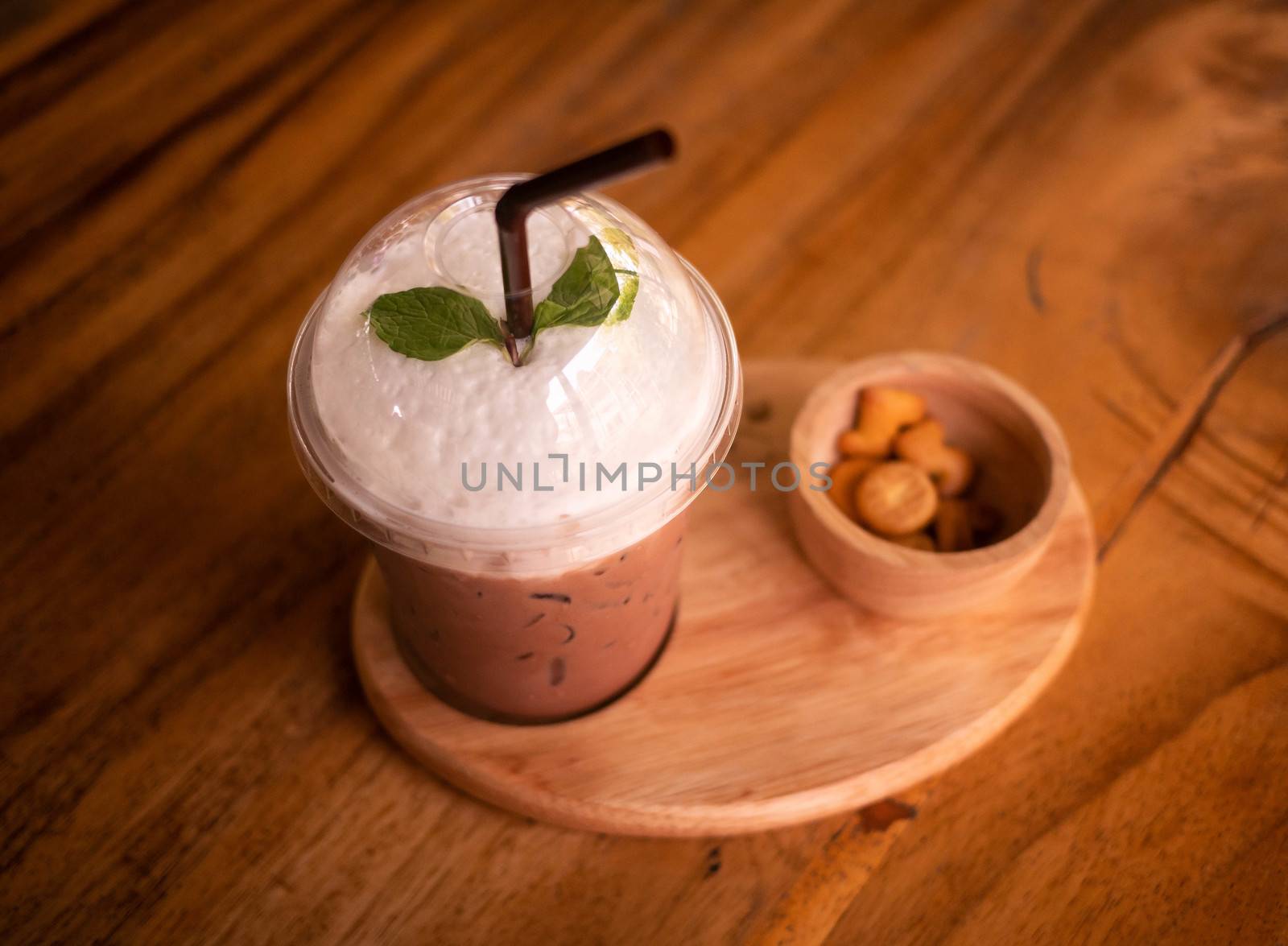 Ice chocolate or cocoa milk served with biscuits on wooden table, top view.