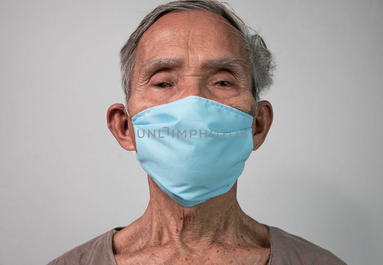 Portrait of Asian senior men wearing facial mask for protection from air pollution or virus epidemic on grey background. Health care concept. by TEERASAK