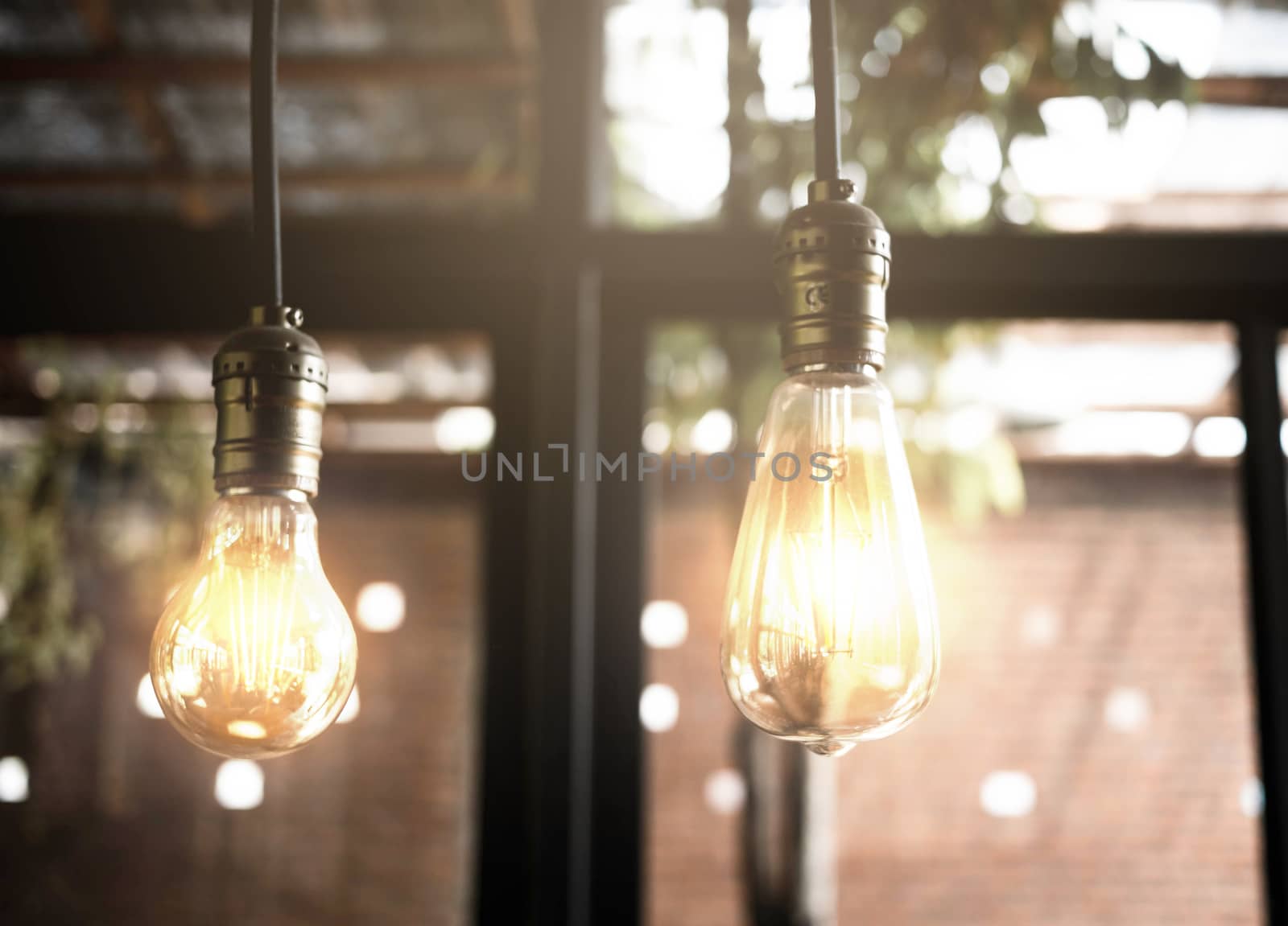 Decorative antique edison style light bulbs in the cafe. Lighting decor indoors concept. by TEERASAK