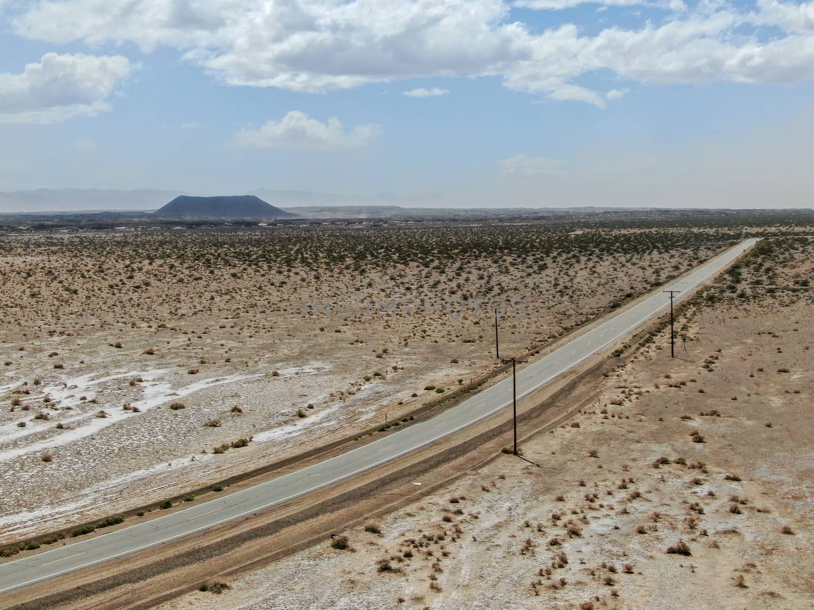 Aerial view of endless desert straight dusty asphalt road in Joshua Tree Park. USA. by Bonandbon