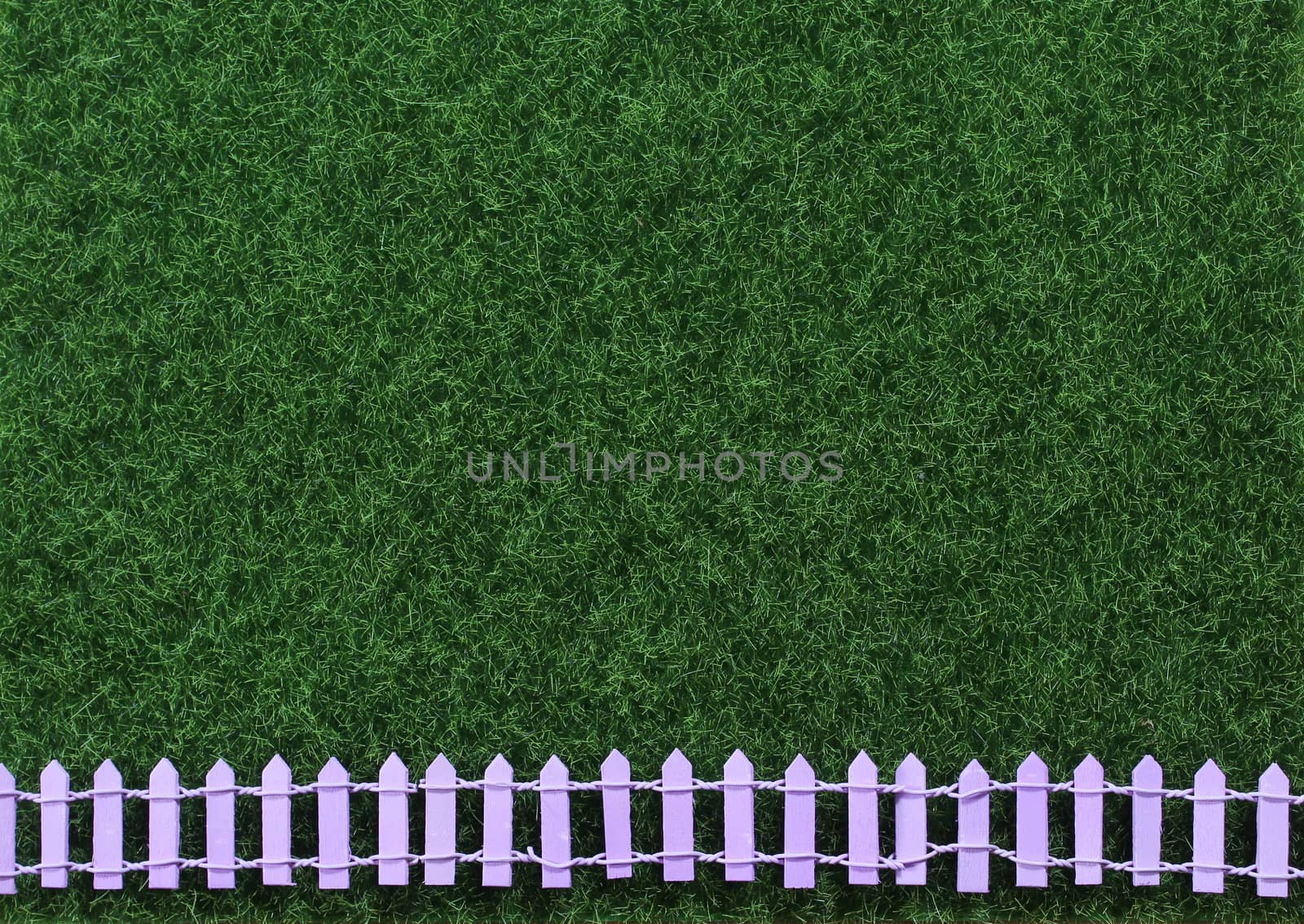 Artificial Green Grass With Picket Fence Background