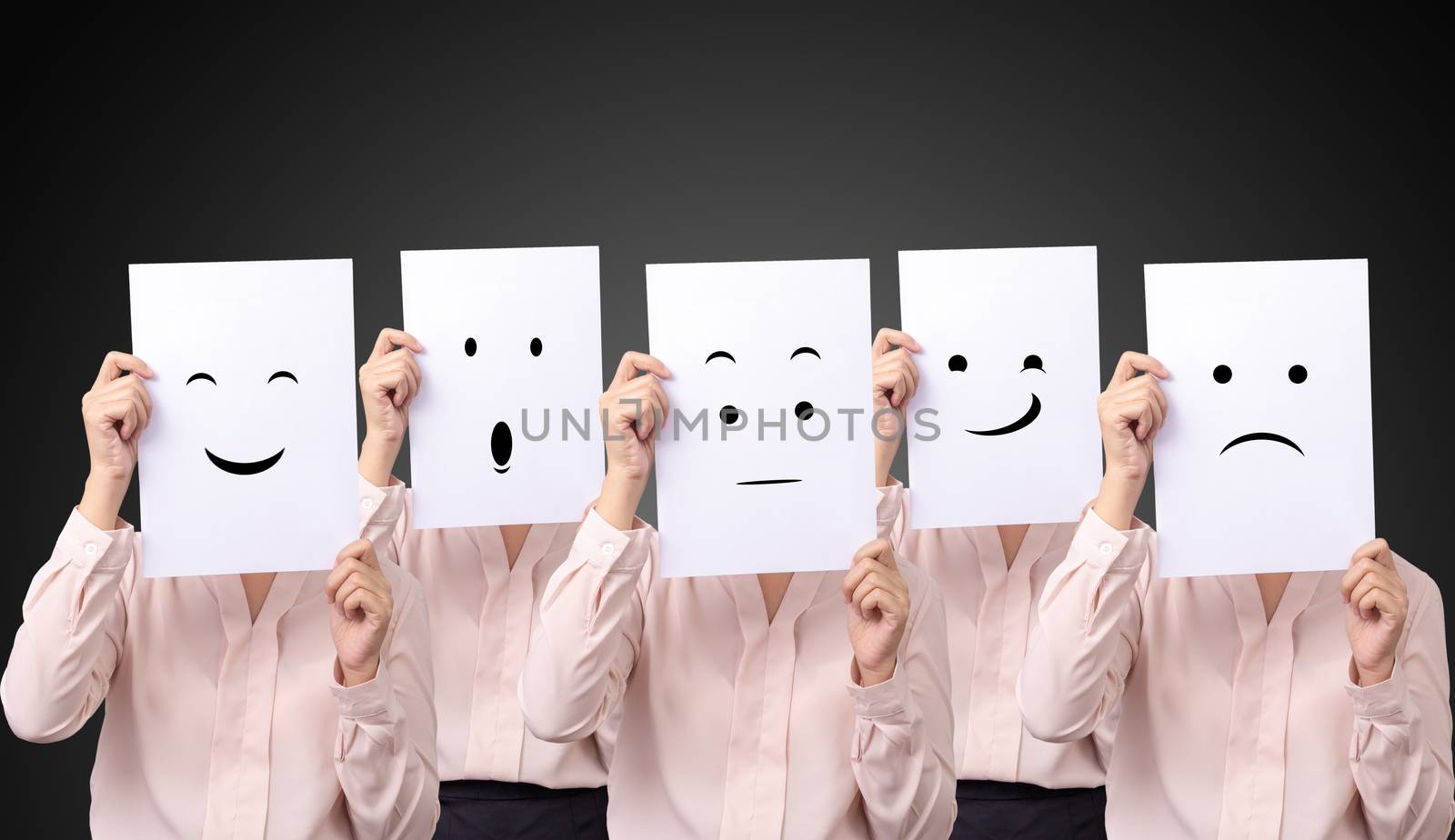 five businesswoman holding a card with drawing facial expressions different emotion feelings face on white paper by asiandelight
