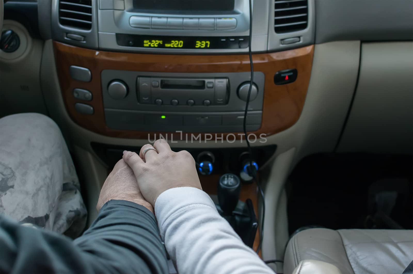 touching the hands of men and women, on the background of controls, receiver and car panel by jk3030