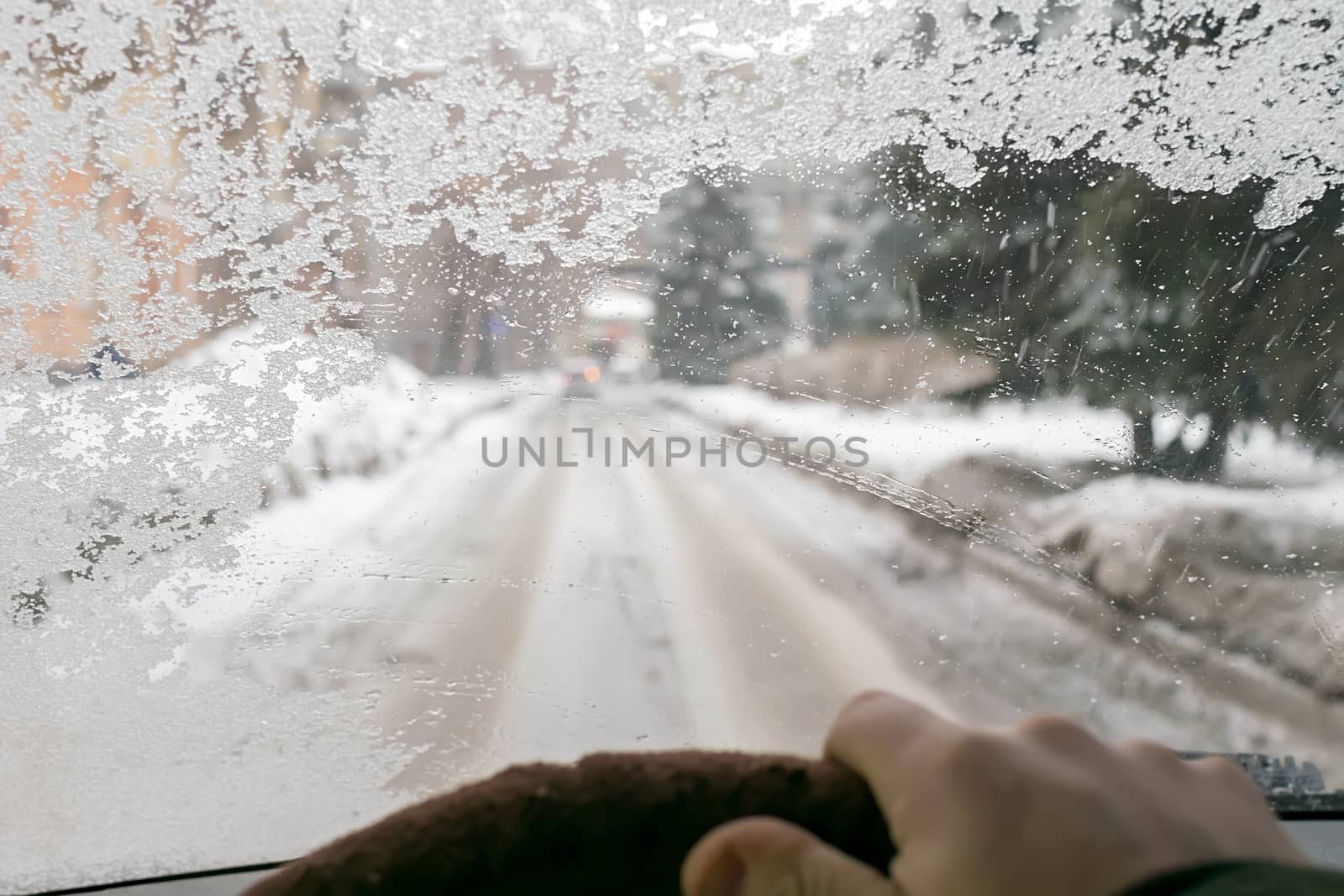 view of the fogged icy cold windshield of the car from the driver's side of the car