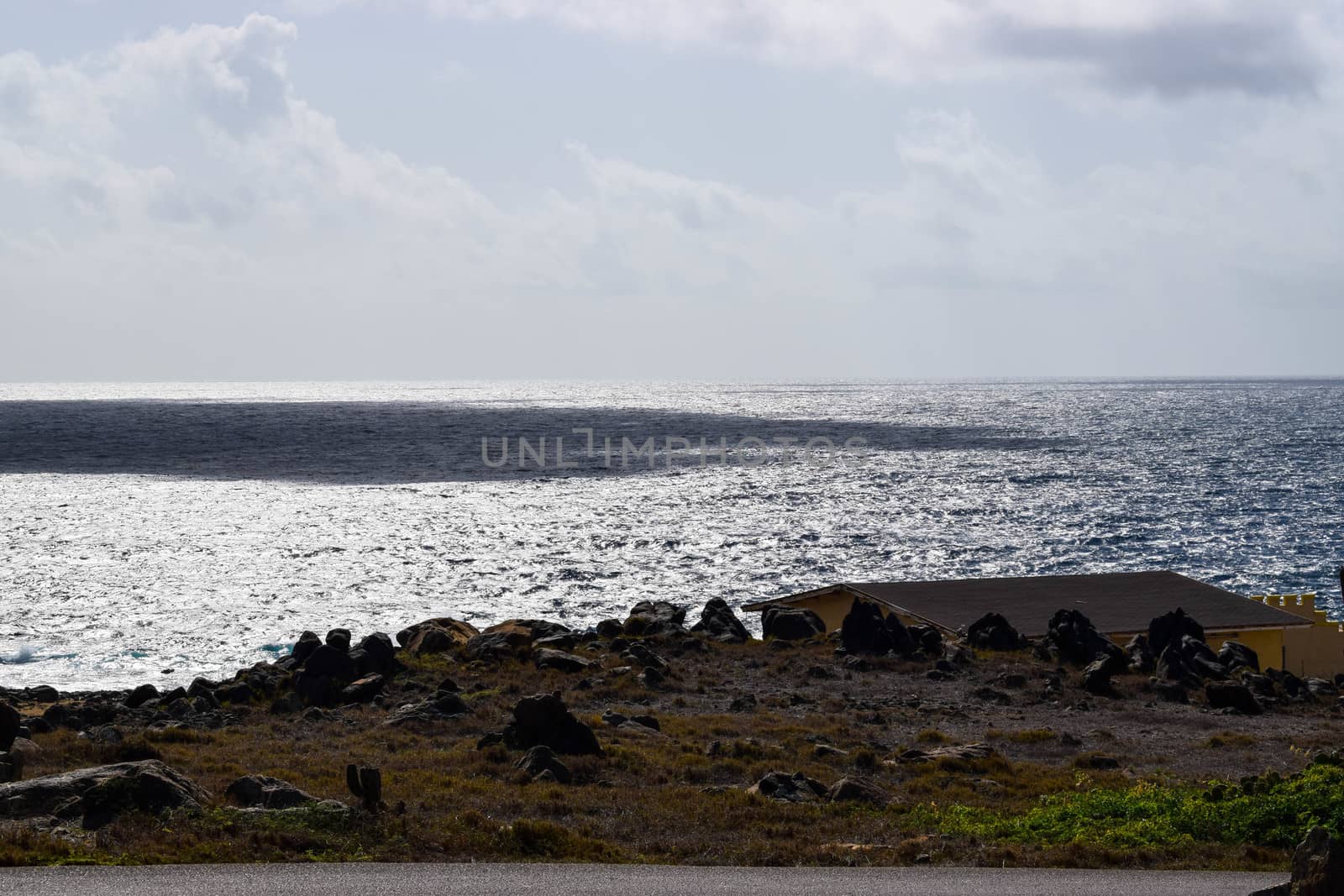 Arikok Natural Park on the island of Aruba in the Caribbean Sea with deserts and ocean waves on the rocky coast by matteobartolini