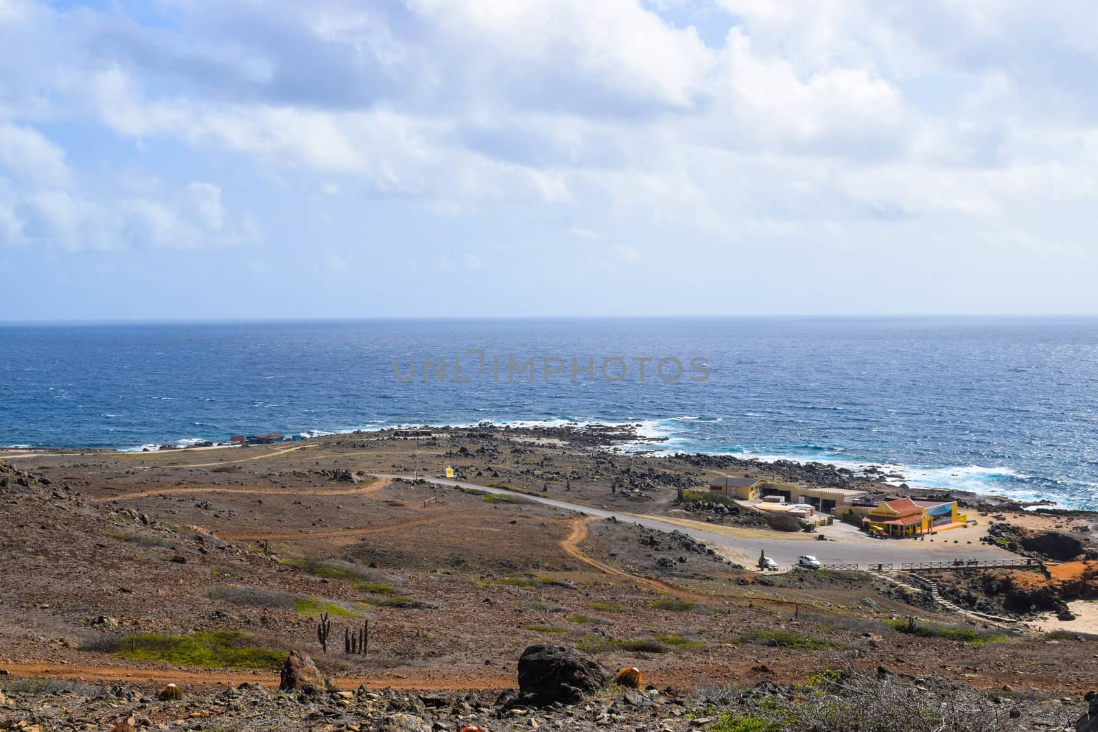 Arikok Natural Park on the island of Aruba in the Caribbean Sea with deserts and ocean waves on the rocky coast by matteobartolini