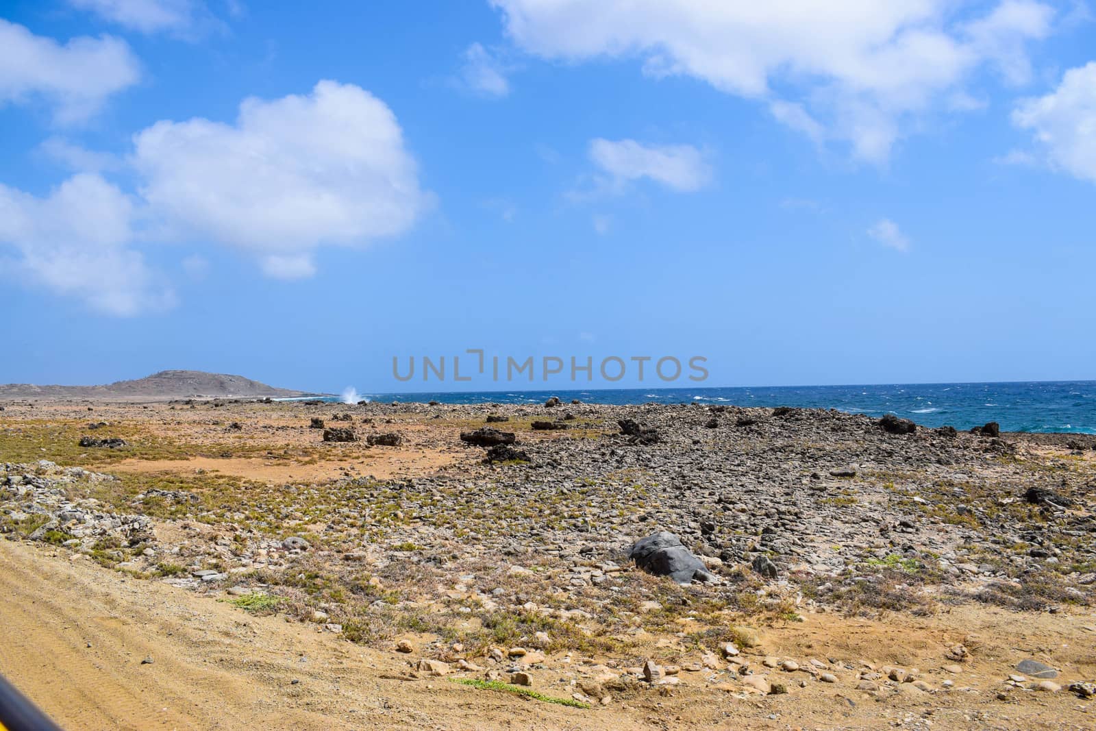 Arikok Natural Park on the island of Aruba in the Caribbean Sea with deserts and ocean waves on the rocky coast by matteobartolini