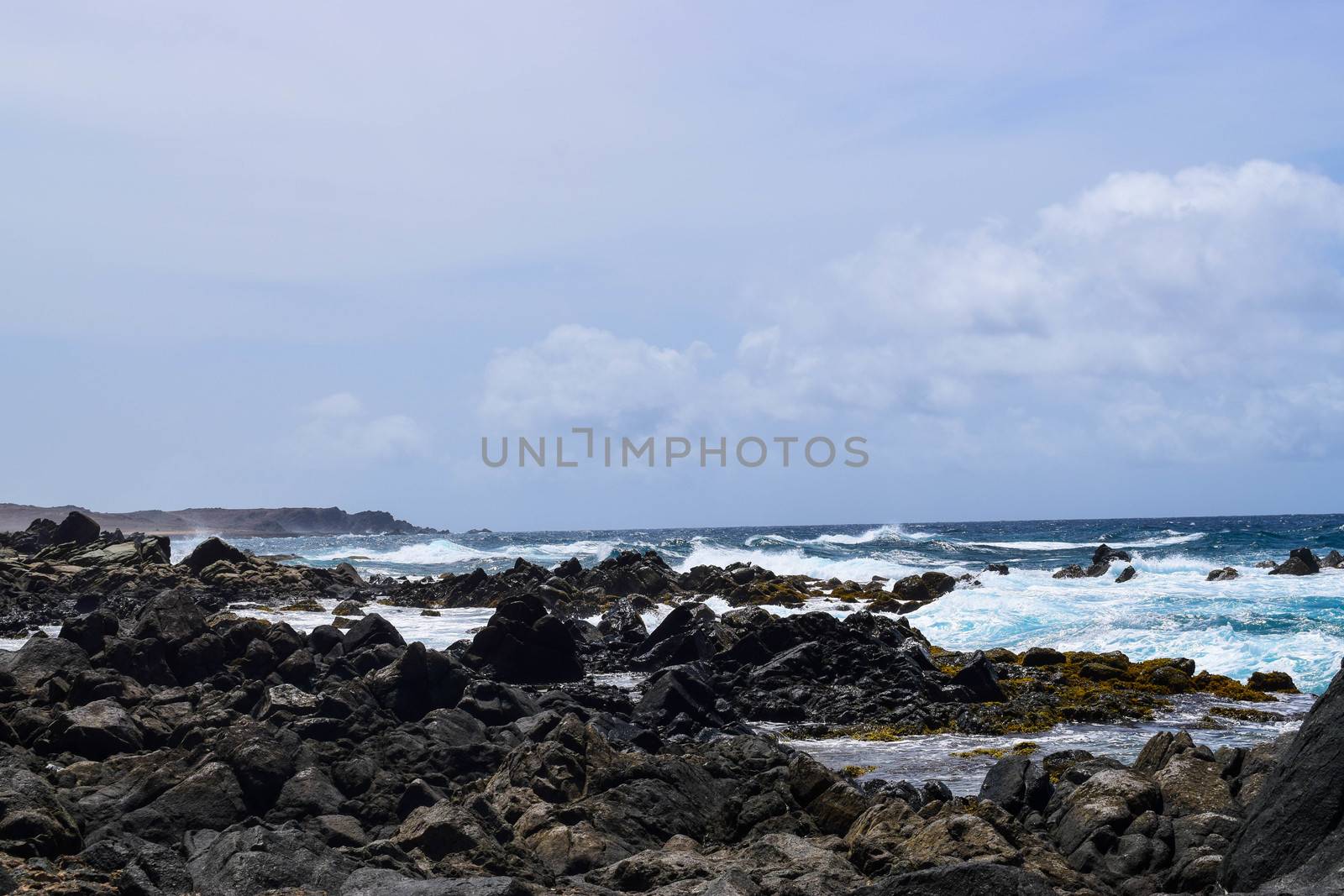 Arikok Natural Park on the island of Aruba in the Caribbean Sea with deserts and ocean waves on the rocky coast