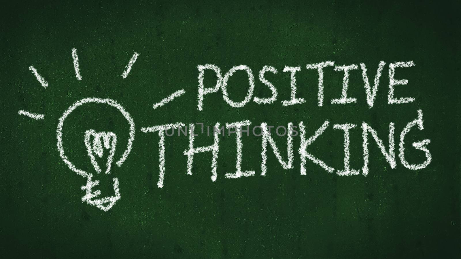 positive thinking concept. handwritten word positive thinking on black chalkboard with light bulb as idea