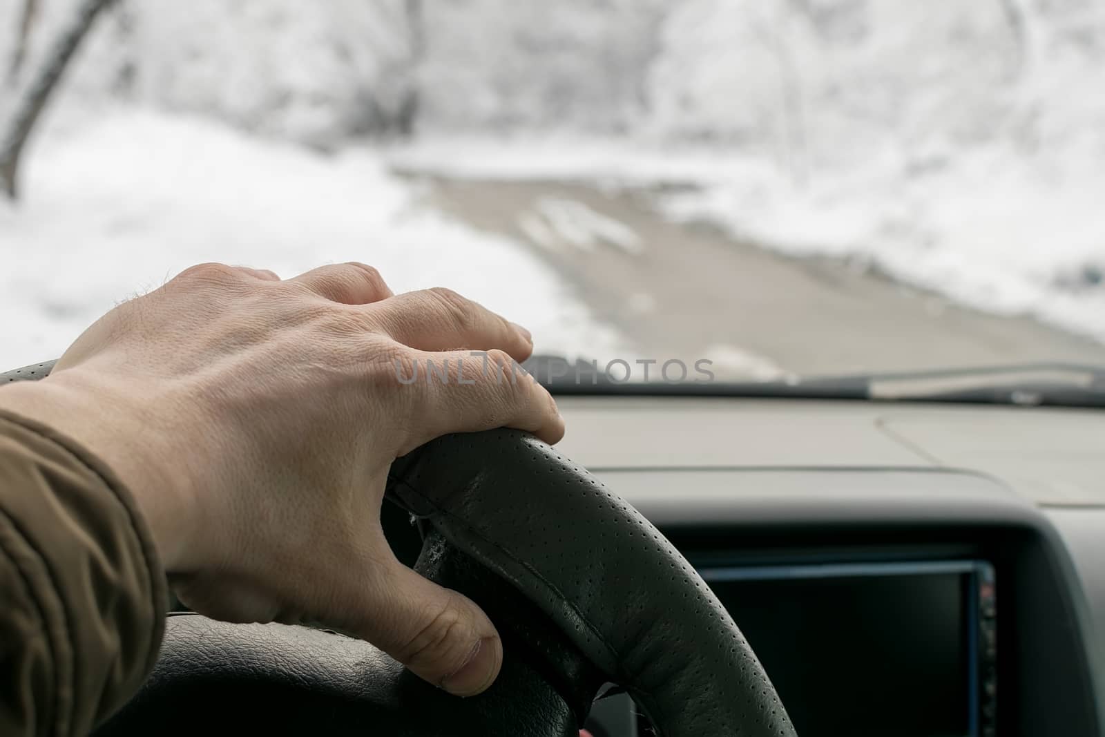 Man's hand on the steering wheel of a car by jk3030