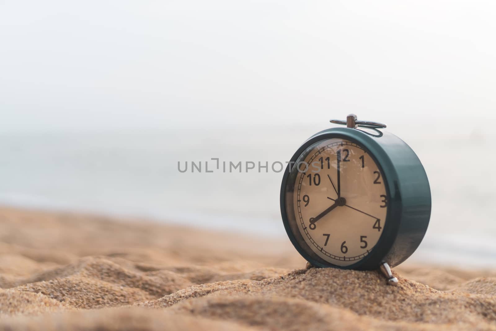 Selective focus of alarm clock on side table beside bed show 8 o'clock in the morning background.Time in life early bird person productive concept.
